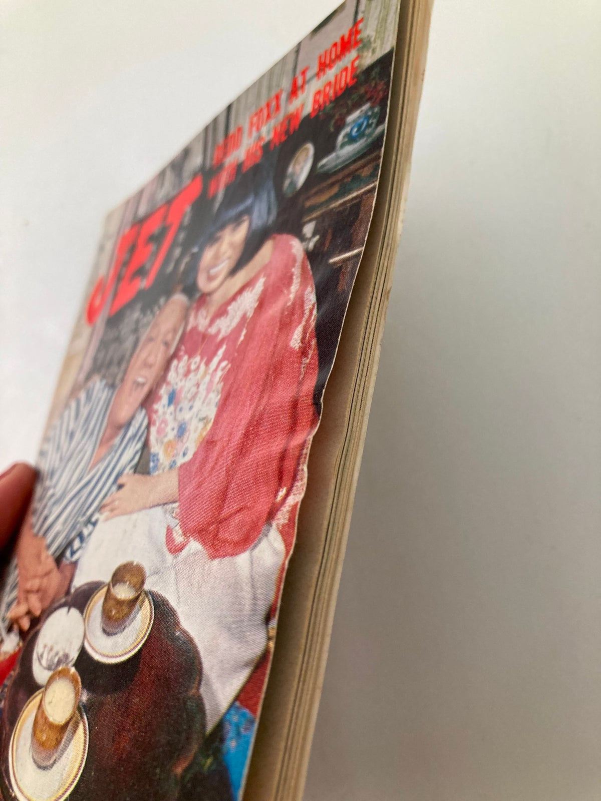Side view of the Vintage Jet Magazine from February 3, 1977, featuring Redd Foxx and his New Bride. The magazine shows some wear and a slight curve along the spine, indicating its vintage condition.
