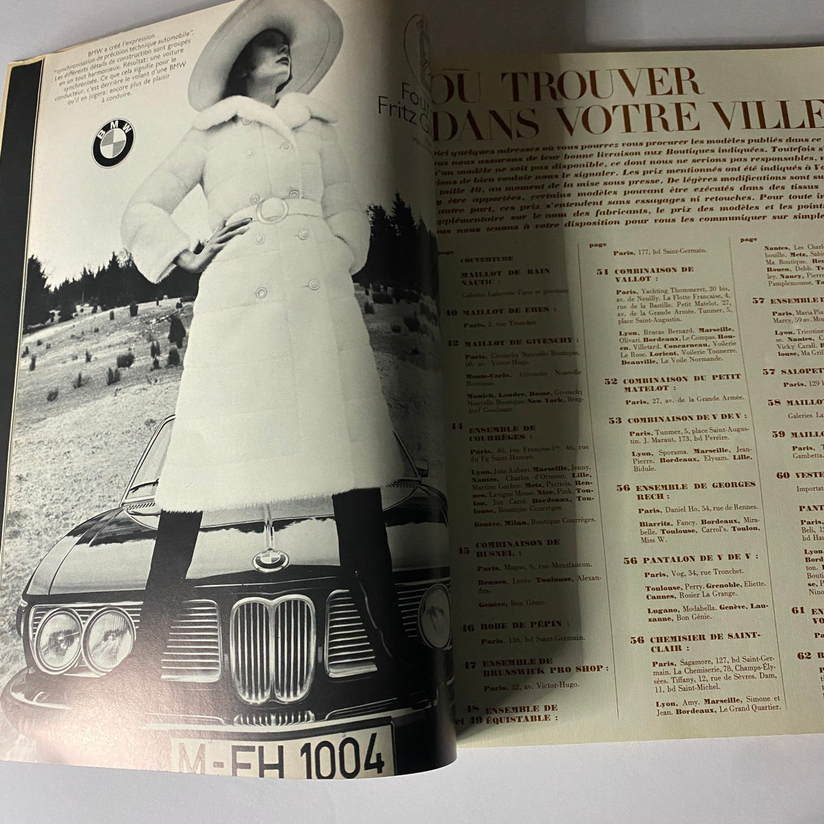 Fashion advertisement spread from Vogue Paris Magazine June - July 1971 featuring a model dressed in a stylish winter coat, posing on a vintage BMW car, encapsulating the essence of 1970s fashion.