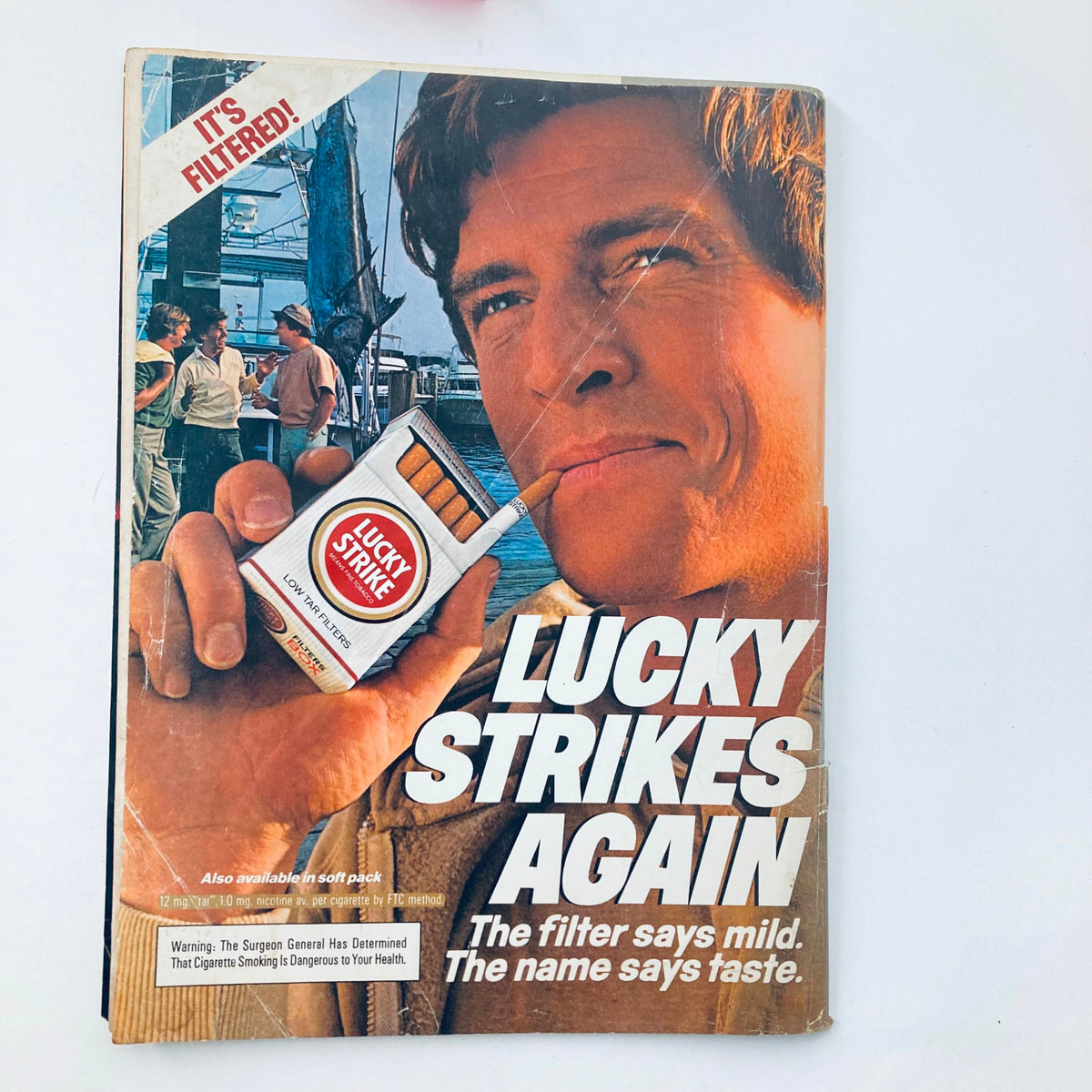 Vintage National Lampoon Magazine October 1983, featuring a cover image of a man holding a Lucky Strike cigarette, promoting the tagline 'Lucky Strikes Again.' This issue includes Brooke's Letter Home and exhibits creased corners for a vintage charm.