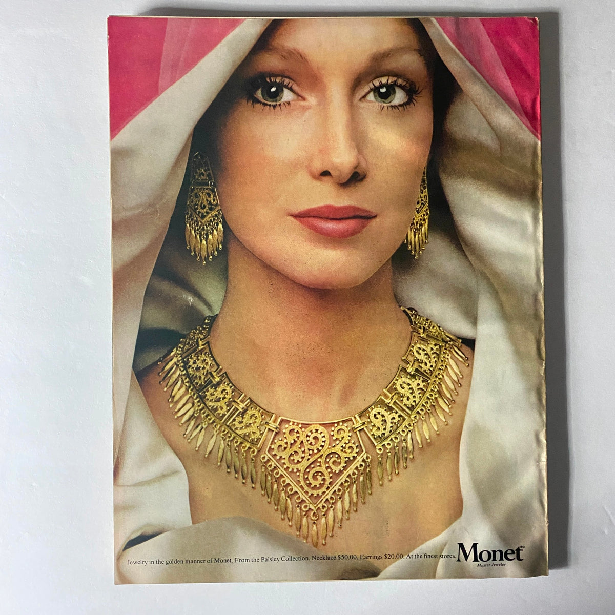 Cover of Harper's Bazaar Magazine April 1973 with a focus on a model adorned in golden jewelry from Monet, showcasing the elegance of 1970s fashion style combined with costume jewelry.