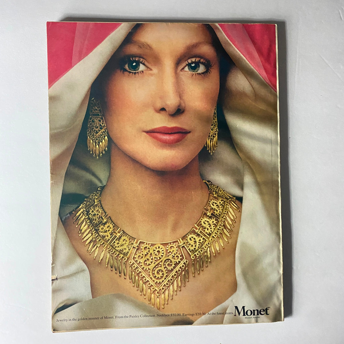 Back cover of Harper's Bazaar Magazine February 1973 showcasing a model wearing stunning jewelry from Monet, emphasizing fashion trends and accessories of the era.