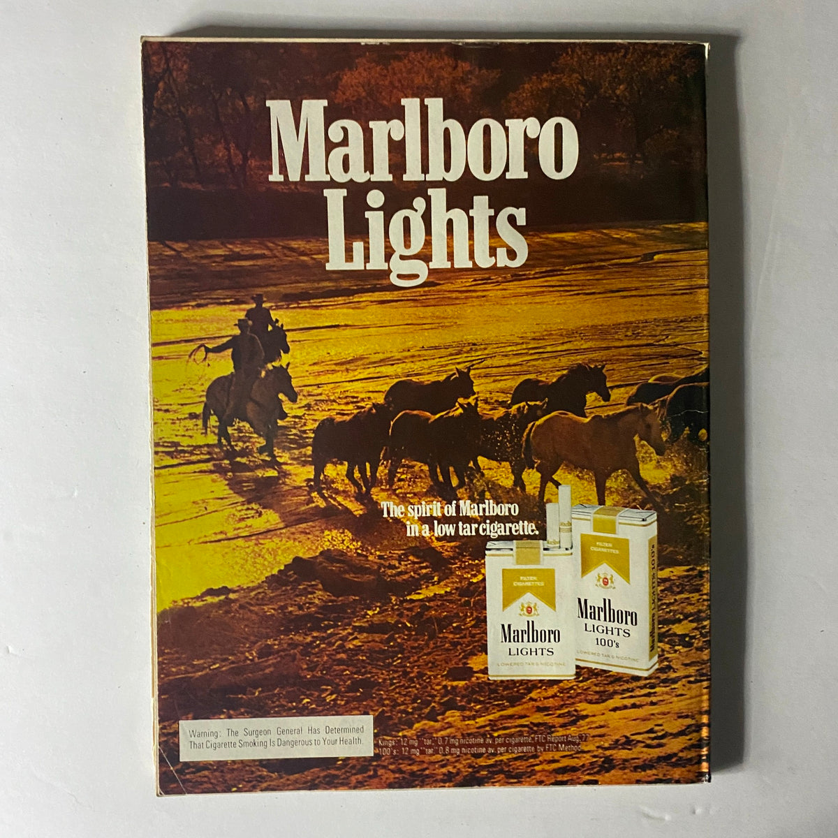 Marlboro Lights advertisement featuring horseback riders in a sunset landscape, promoting Marlboro cigarettes as a low tar option, highlighted by the title 'Marlboro Lights'.