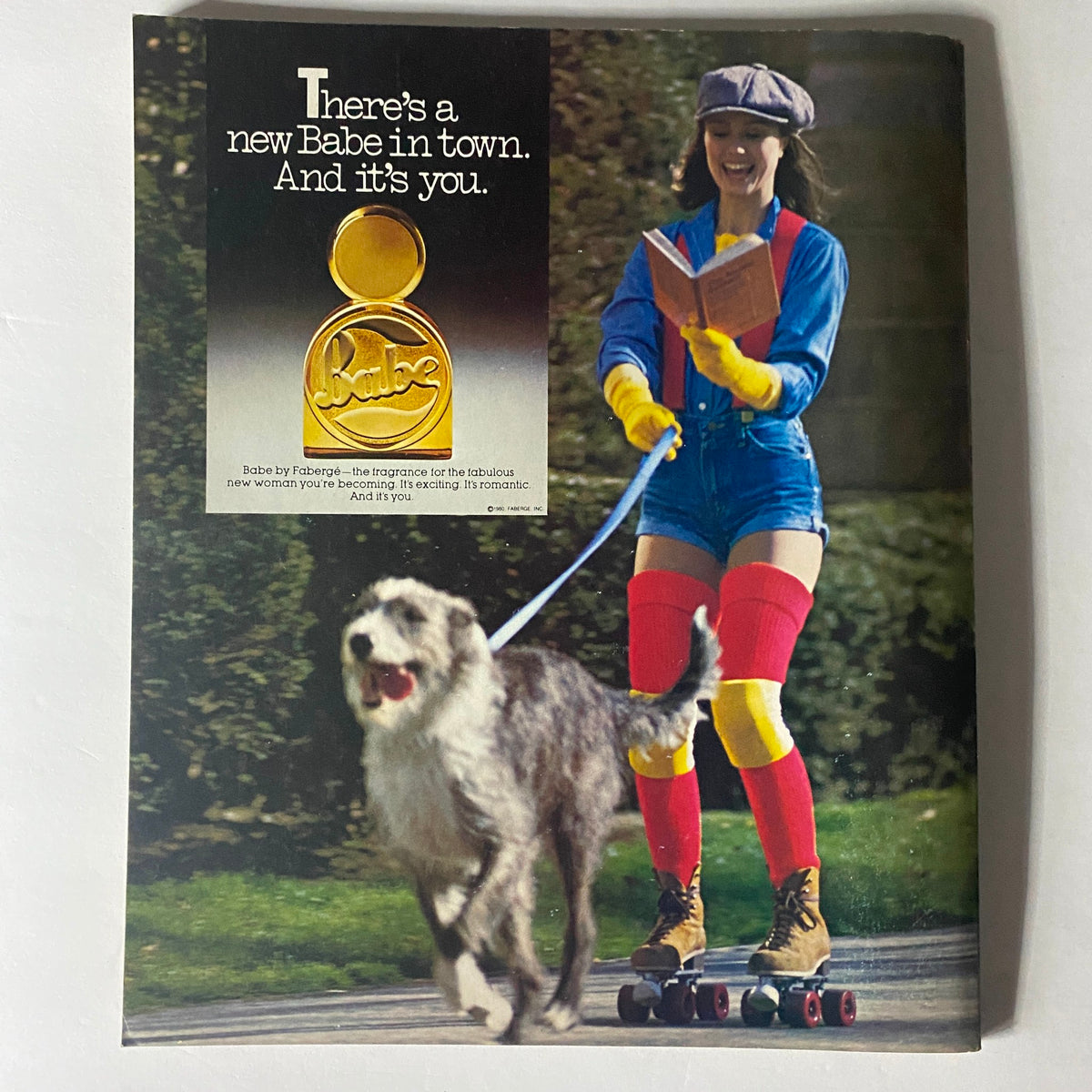 Retro advertisement for Babe by Fabergé in Harper's Bazaar Magazine May 1980, featuring a stylish woman roller skating with her dog, emphasizing the fun and bold style of the era.