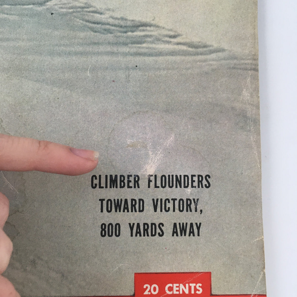 Detail shot of the text on the VTG Life Magazine cover from October 11, 1954, emphasizing the phrase 'Climber Founders Toward Victory, 800 Yards Away'. The photo captures the magazine's vintage character.