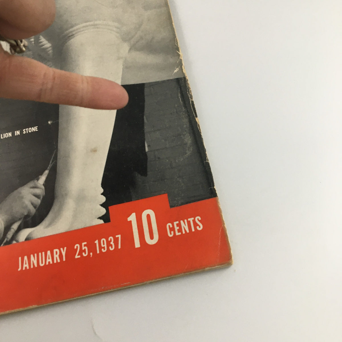 Detail view of VTG Life Magazine January 25, 1937 showing the magazine's bottom section with price and date while a hand points towards it.