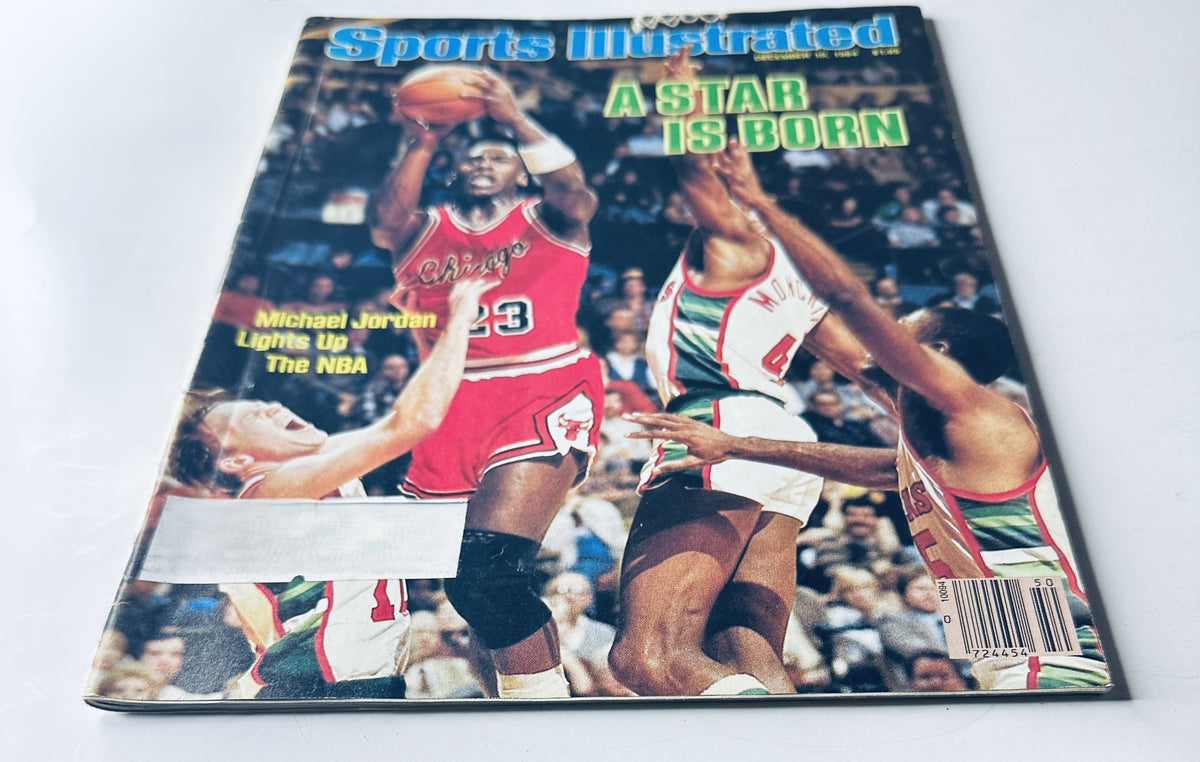 Alternative view of Sports Illustrated Magazine cover from December 10, 1984 featuring Michael Jordan. The cover states 'A Star Is Born' along with the phrase 'Michael Jordan Lights Up The NBA', showcasing Jordan's impact in his early NBA career.