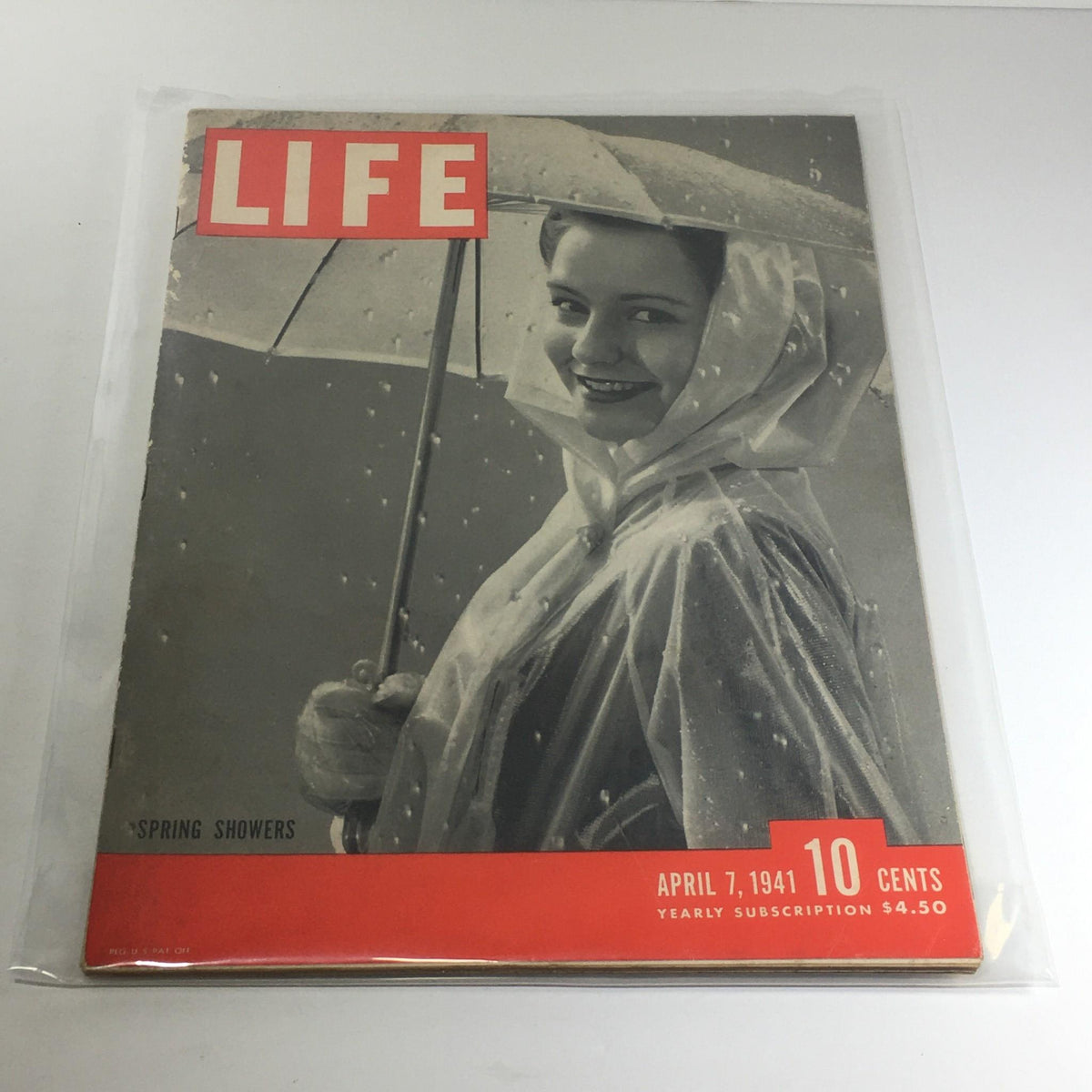 Vintage Life Magazine April 7 1941 - Spring Showers featuring a smiling woman under an umbrella, captured in a nostalgic black and white photograph, highlighting the charm of the 1940s.
