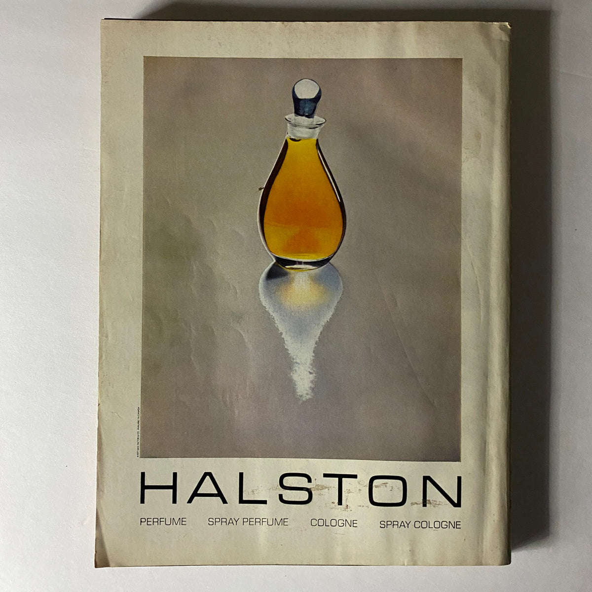 Vogue Magazine May 1977 advertisement for Halston perfume, showcasing a sleek bottle design reflecting the minimalist style of the era.