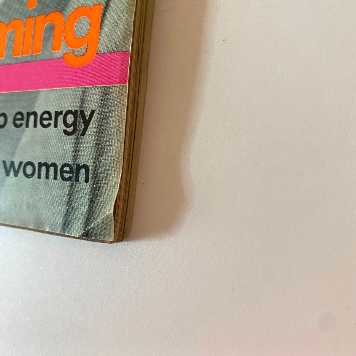 Side view of Vogue Magazine January 1976, showcasing the title and keywords such as 'non-stop energy' and 'mistreating women'.