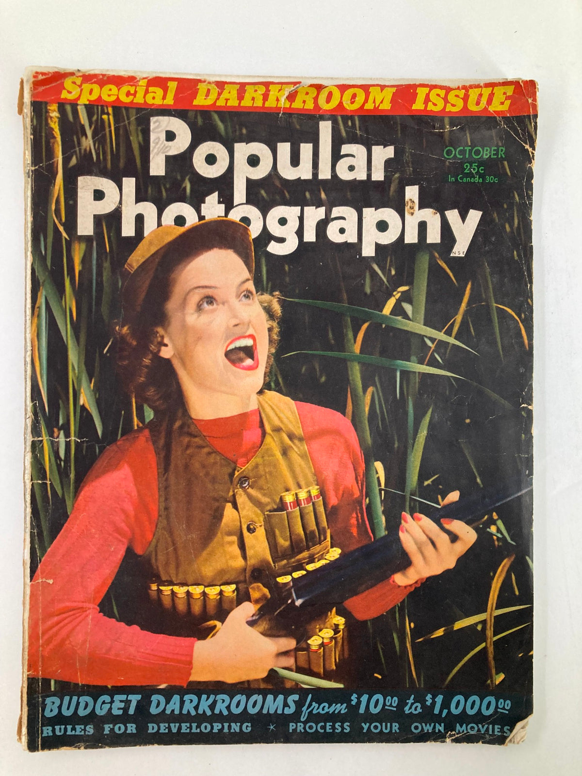 Vintage Popular Photography Magazine from October 1940, featuring a woman with a joyous expression on the cover, promoting budget dark room techniques, surrounded by greenery.