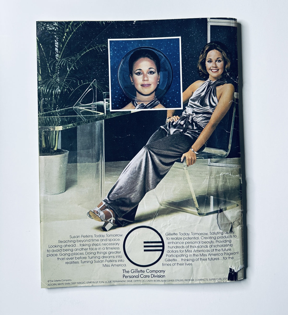 The back cover of the Miss America Pageant Magazine, showcasing Susan Perkins seated in a stylish setting, with a focus on her role as a beauty queen. The text highlights her association with Gillette as part of the Personal Care Division.