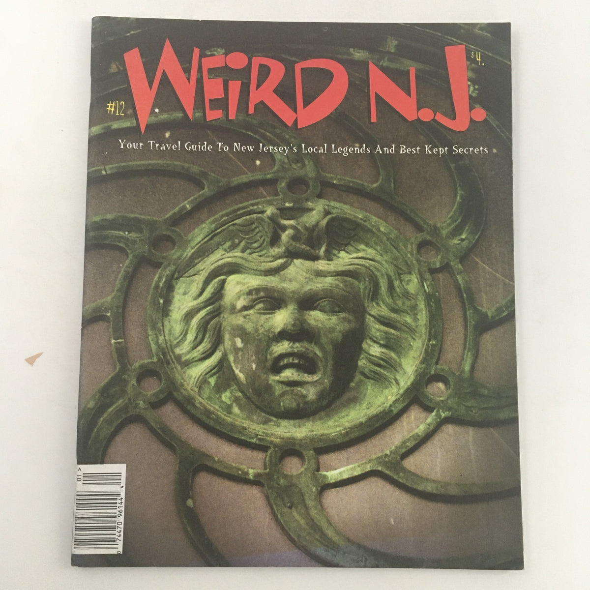 Cover of Weird N.J. Magazine 1999 Issue #12 featuring a striking image of a green decorative face, serving as a travel guide to New Jersey's local legends and best-kept secrets.