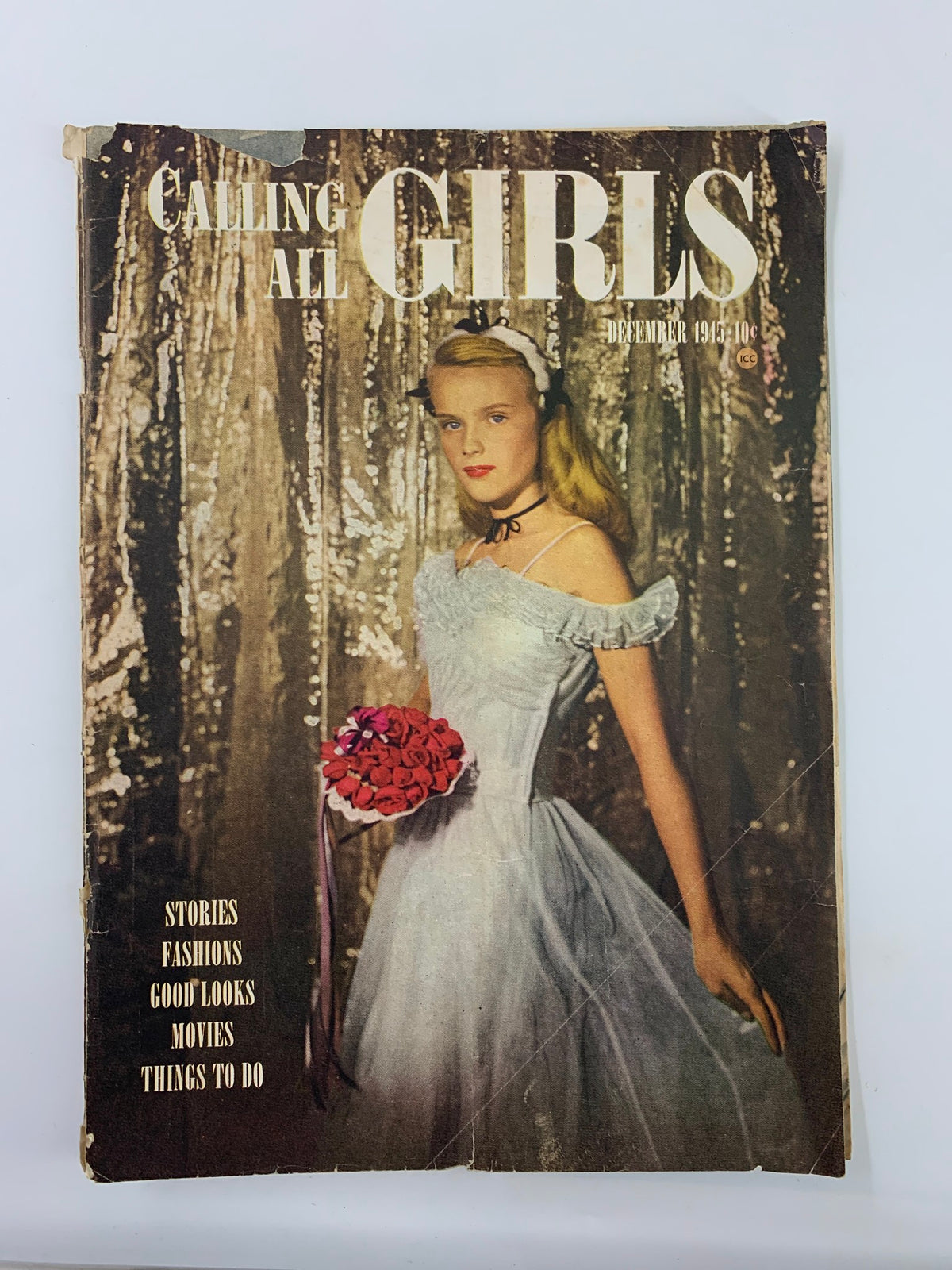 VTG Calling All Girls Magazine December 1945 cover featuring a young woman in a light blue dress holding a bouquet of roses, embodying the festive spirit of Christmas.