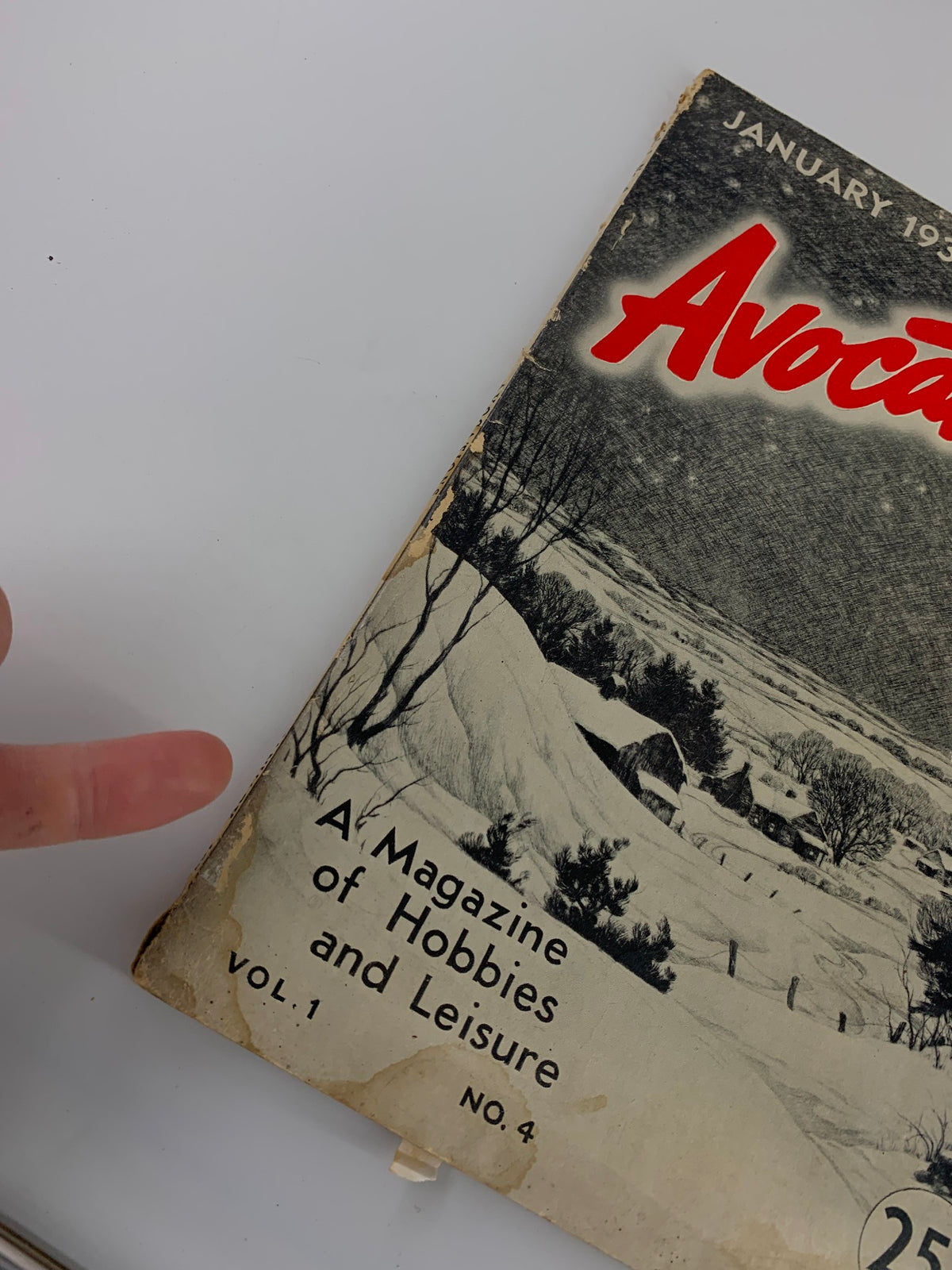 Close-up of the cover of VTG Avocations Magazine January 1938, highlighting the title and the snowy landscape with a finger pointing at the text.