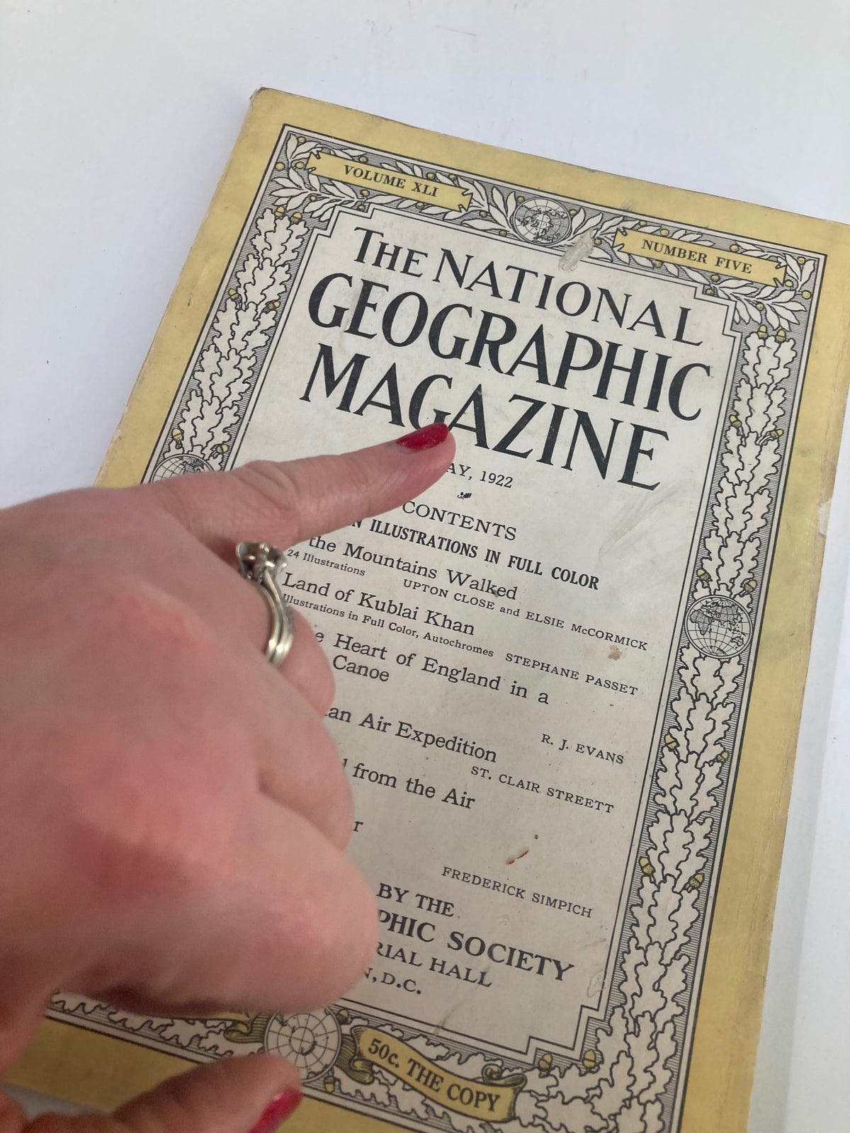 Close-up of VTG The National Geographic Magazine May 1922 cover, highlighting the title and a hand pointing to the article about Kublai Khan, emphasizing its historical significance.