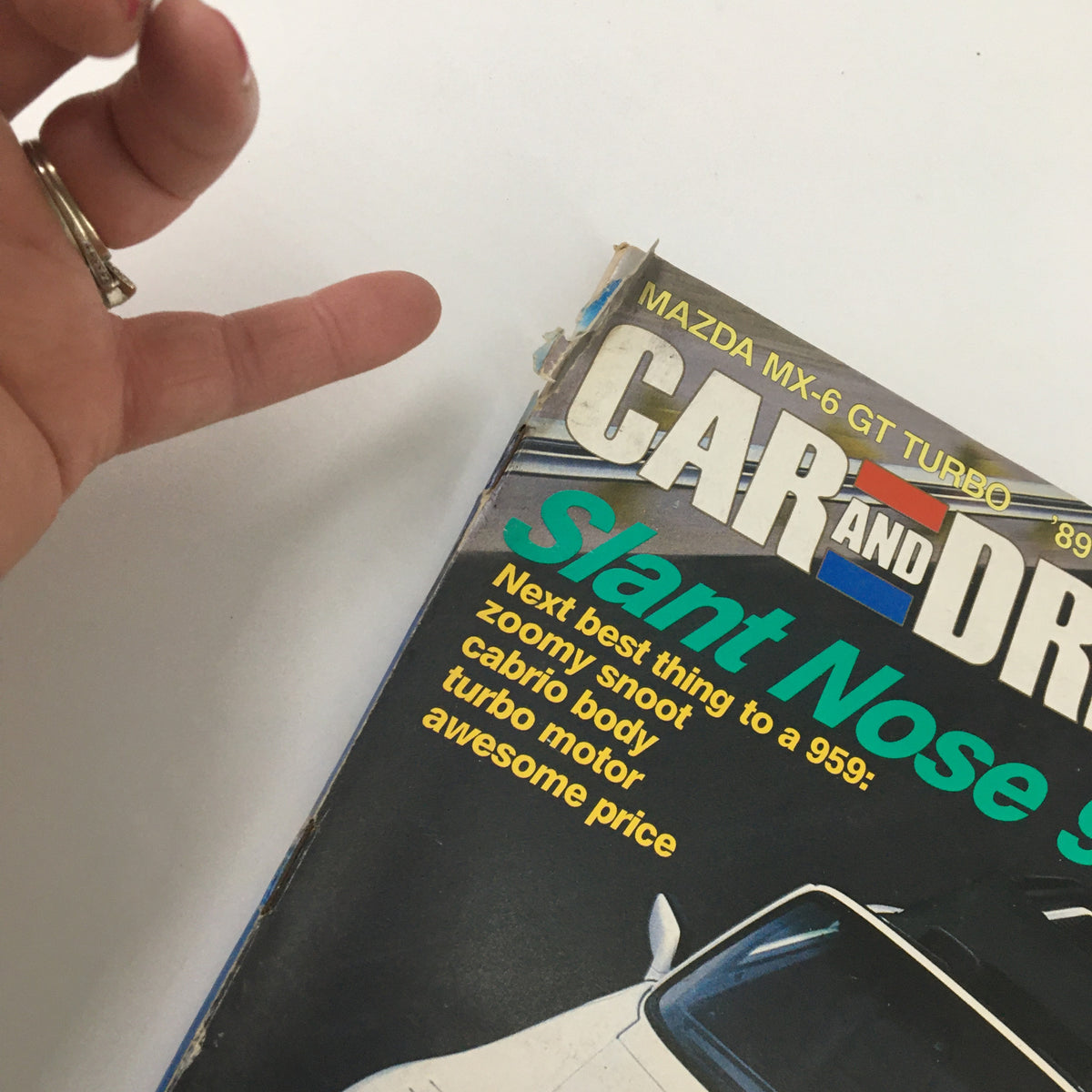 Close-up of the Car and Driver Magazine cover from September 1987, showcasing the Mazda MX-6 GT Turbo and 1989 Mustang, with promotional text highlighting the features of the vehicles.