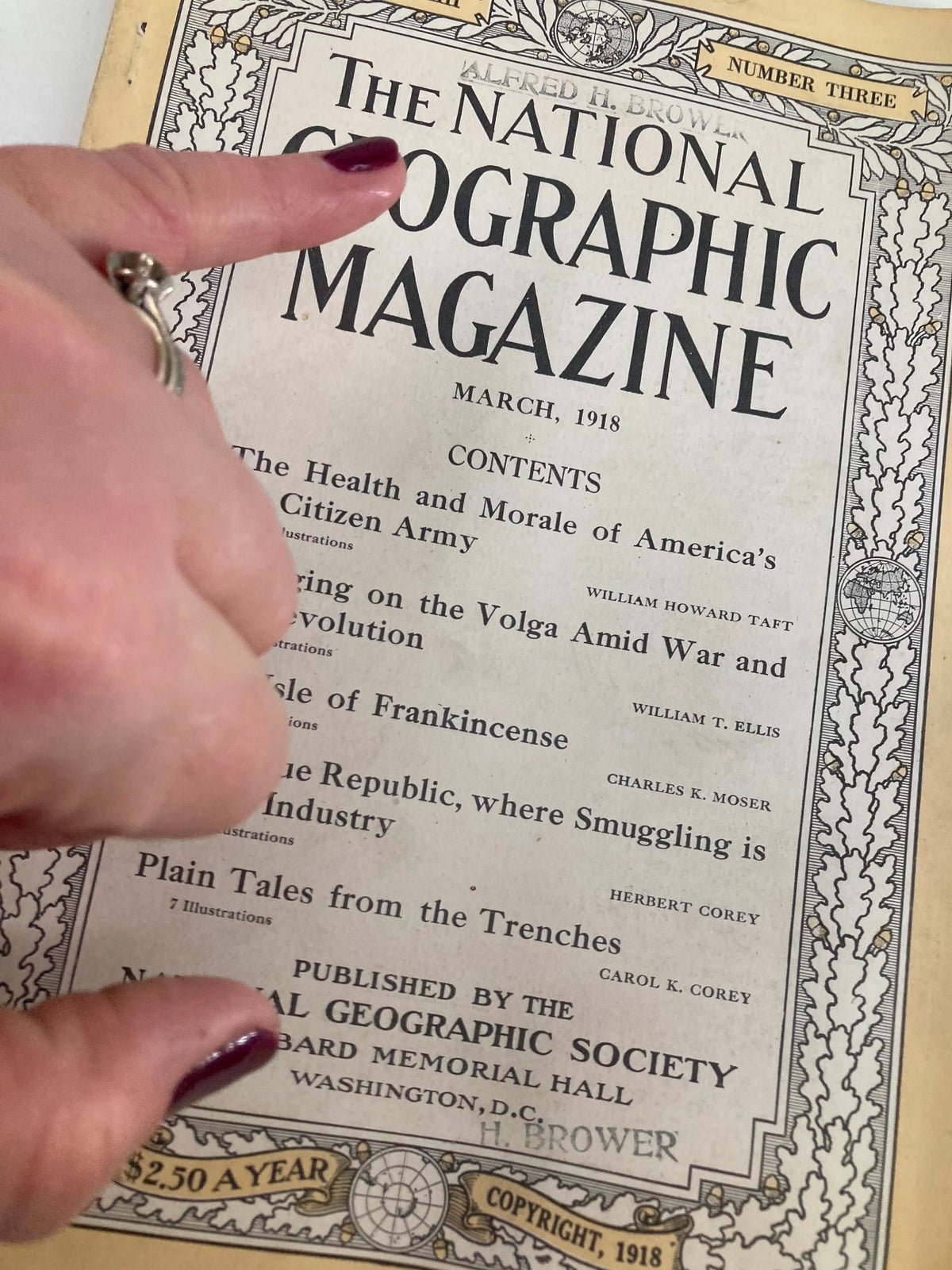 Close-up of the cover page of VTG The National Geographic Magazine March 1918 with a finger pointing to the Isle of Frankincense article.