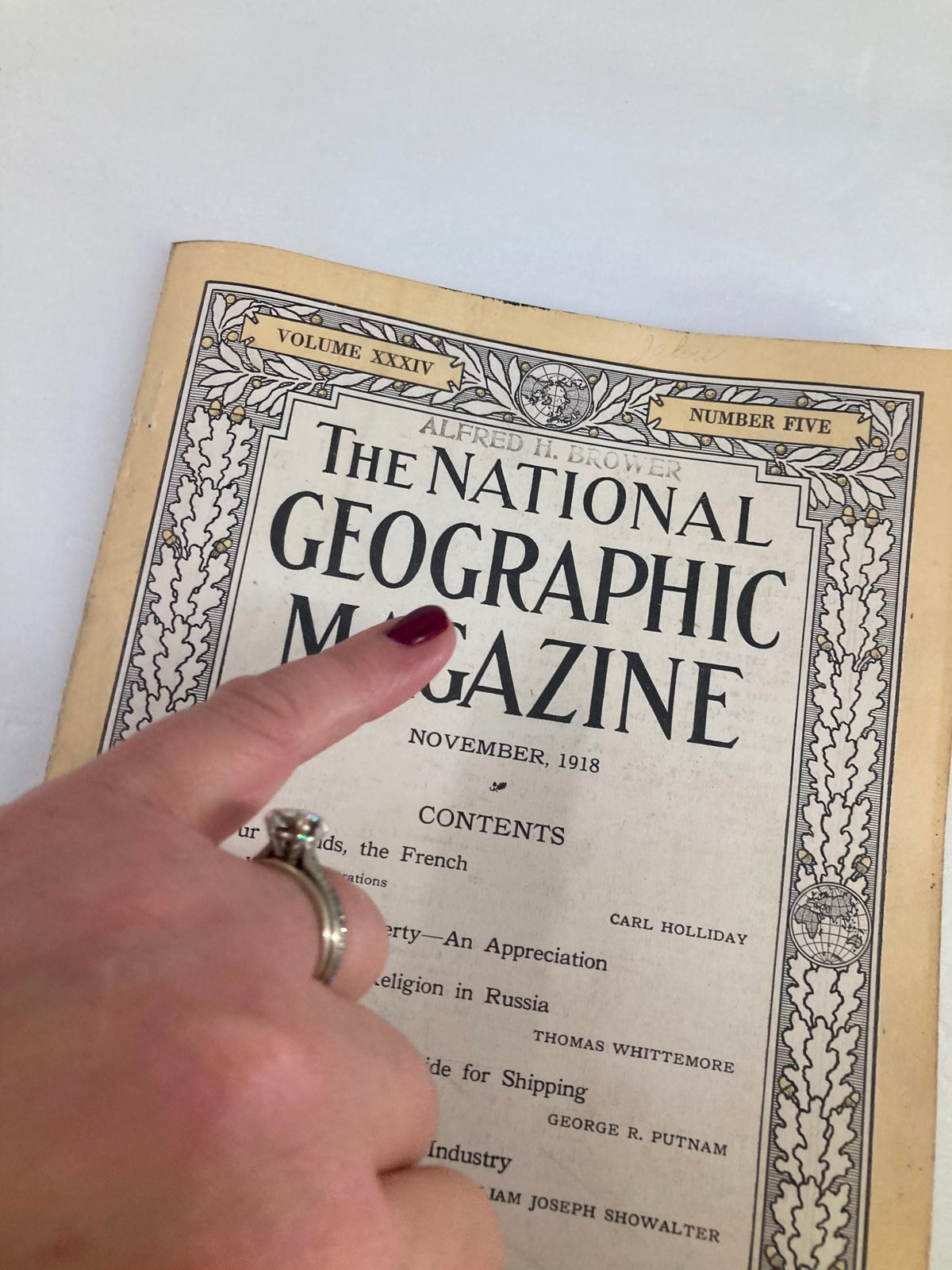 Close-up of the cover of the VTG The National Geographic Magazine November 1918 titled 'The Price of Liberty', showing a hand pointing at the magazine title.