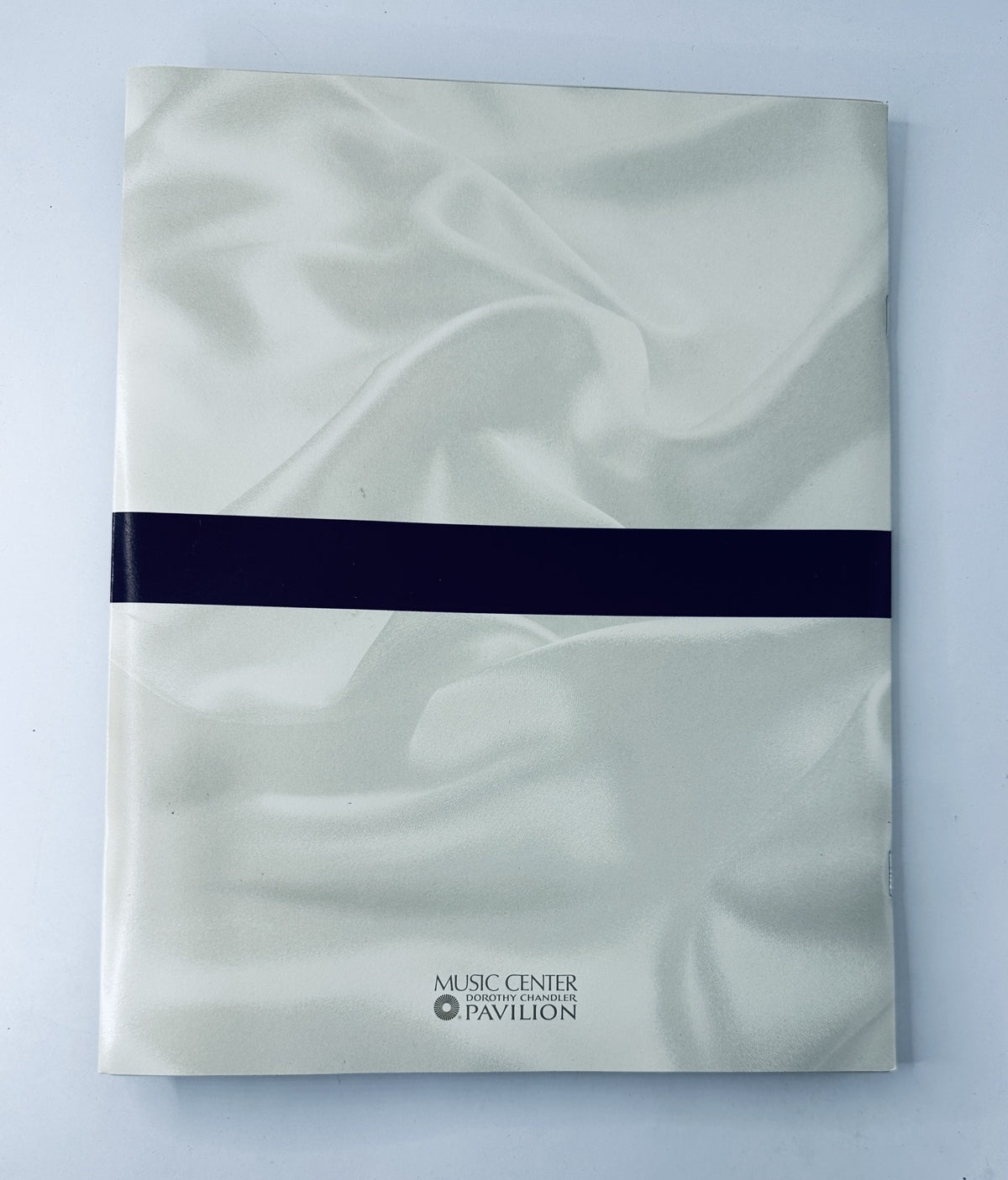 Cover of the Oscars 66th Annual Academy Awards 1994 Program Magazine featuring a sleek white satin design with a black band and the logo of the Music Center Pavilion.