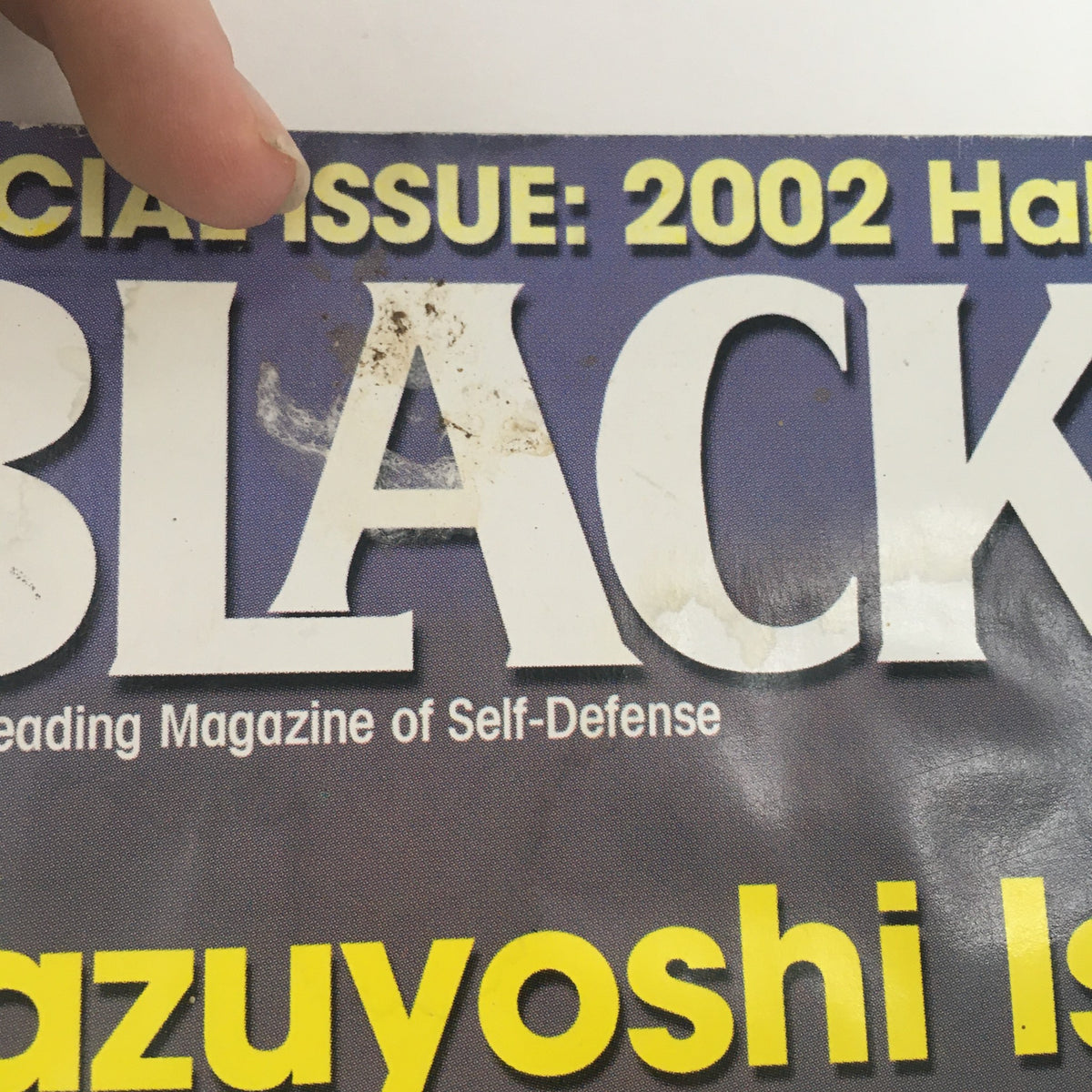 Close-up of Black Belt Magazine January 2003 where the title shows slight wear, featuring Kazuyoshi Ishii and articles on street combat survival skills.