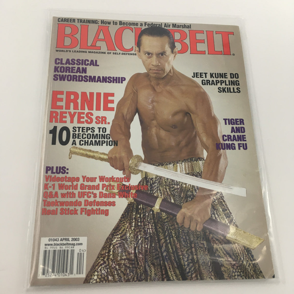 Black Belt Magazine April 2003 featuring Champion Ernie Reyes Sr. on the cover, showcasing martial arts skills with a sword and wearing traditional attire.