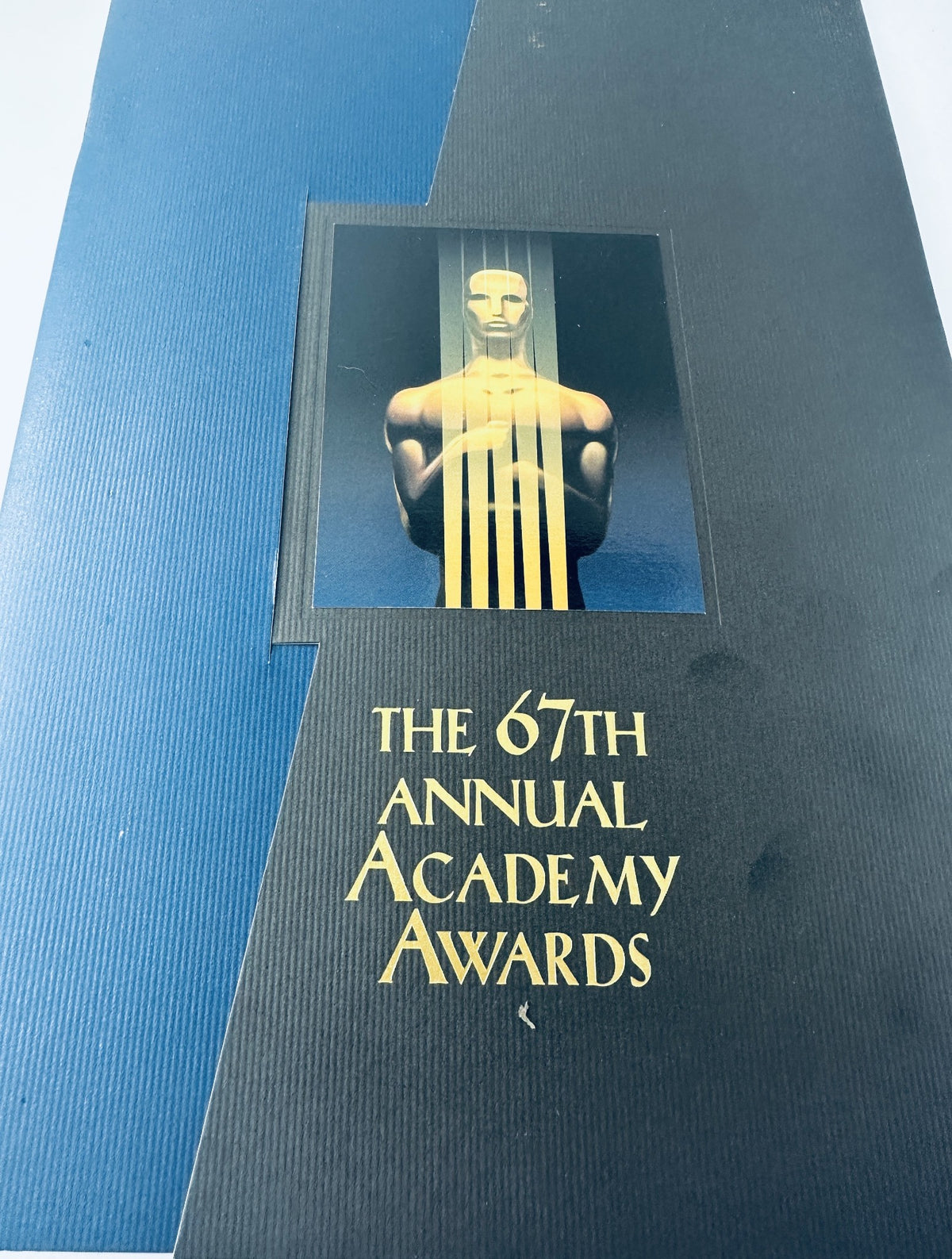 Cover of the 67th Annual Academy Awards Magazine Program, featuring a stylized depiction of the Oscar statue against a blue background with gold lettering.
