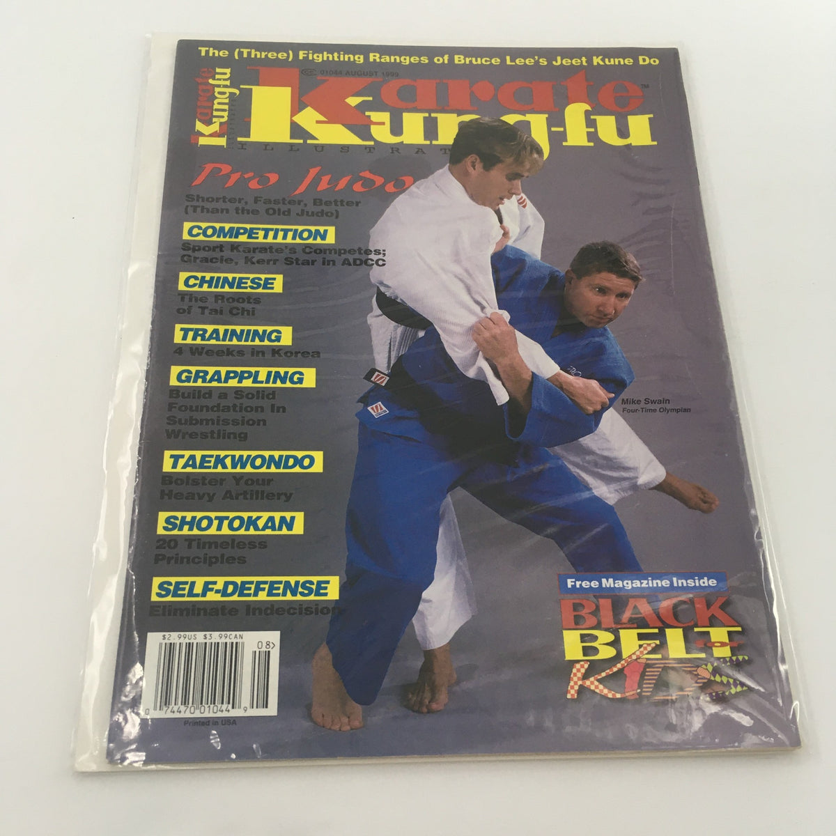 Cover of Karate Kung Fu Illustrated magazine from August 1999 featuring Mike Swain, a four-time Olympian, demonstrating martial arts techniques. The magazine includes topics such as competition, training, grappling, taekwondo, and self-defense.