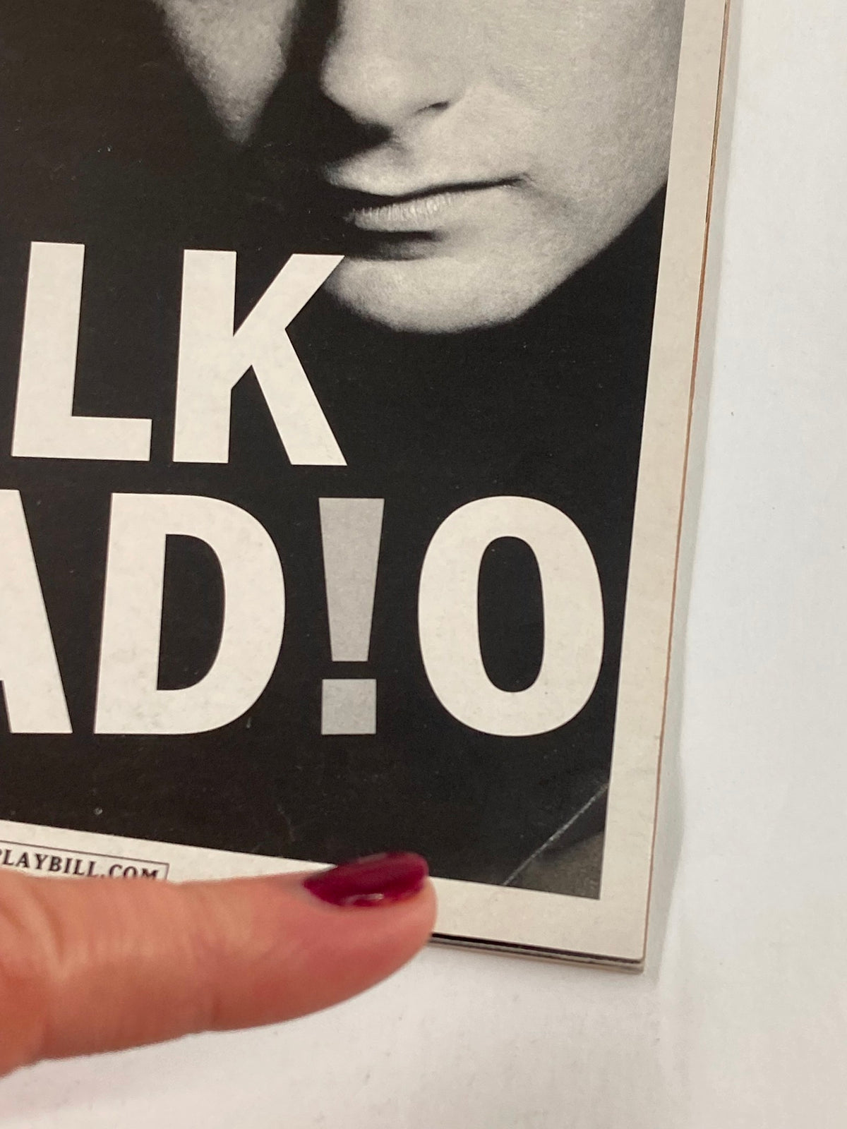 Detailed view of the 2007 Playbill for Talk Radio at Longacre Theatre, highlighting the title and a finger pointing at the cover, revealing the magazine's vintage appeal.