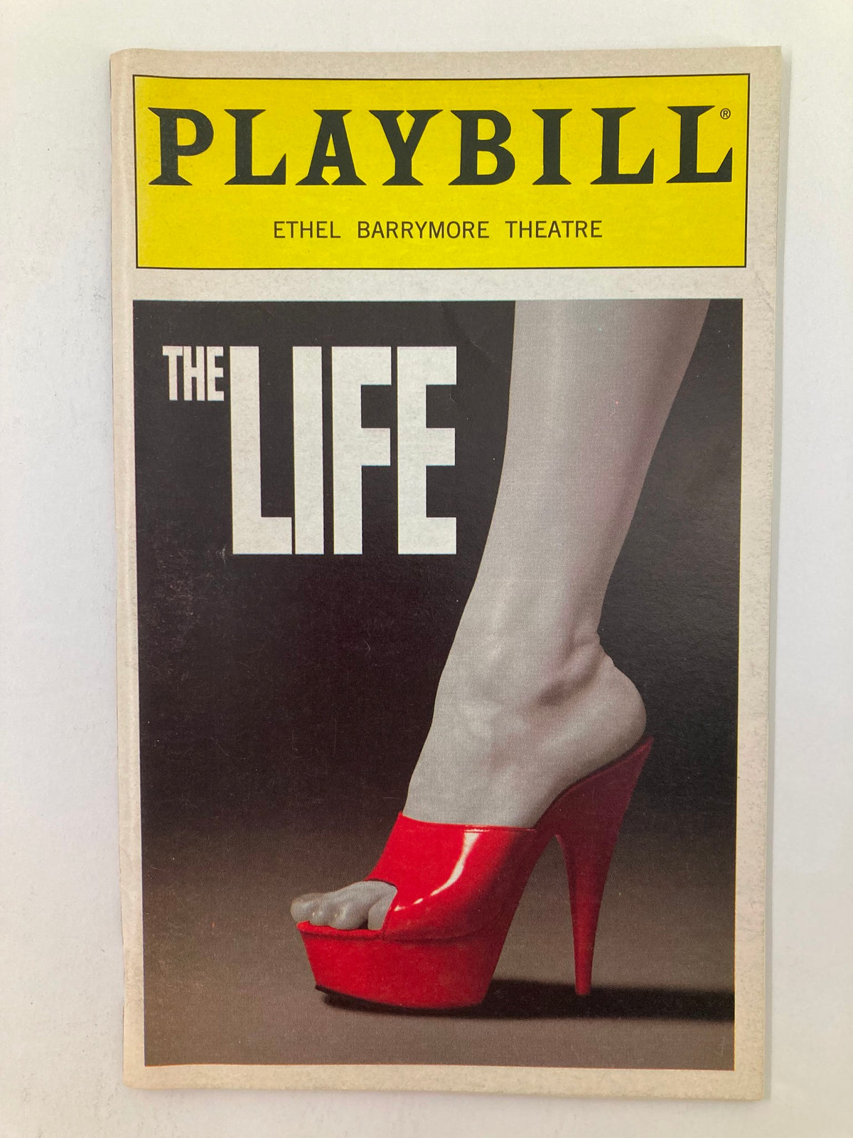 1998 Playbill from Ethel Barrymore Theatre showcasing 'The Life' featuring a striking design with a high-heeled red shoe.