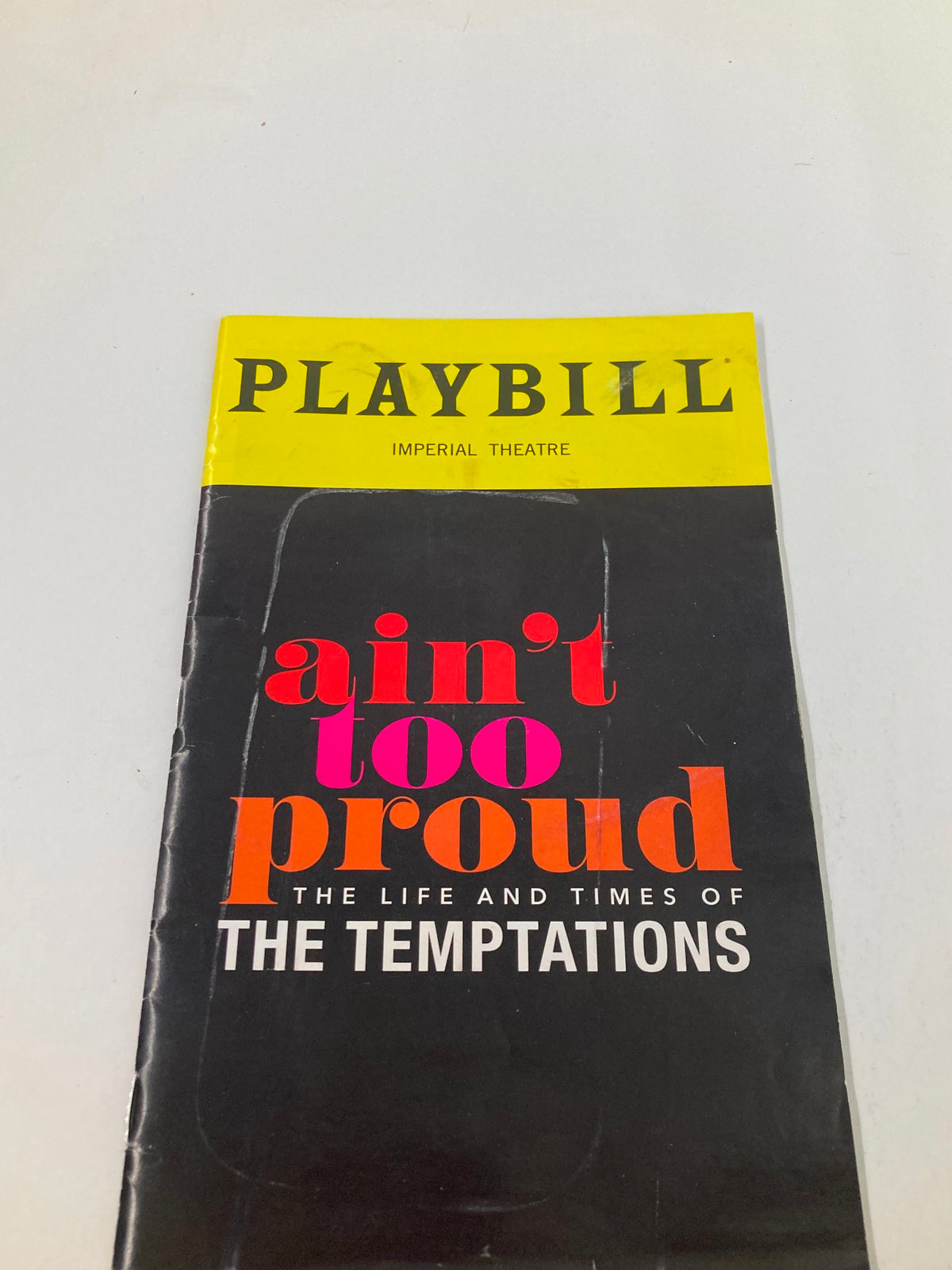 Front cover of the 2019 Playbill from the Imperial Theatre for Ain't Too Proud displaying vibrant colors and bold title.