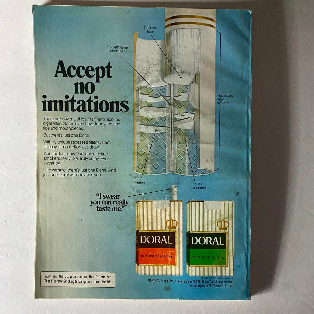 Back cover of Esquire Magazine January 1974 showcasing an advertisement for Doral cigarettes with detailed illustrations of its unique recessed filter system and a bold statement 'Accept no imitations'. The advertisement highlights the features of Doral cigarettes, promising a unique taste experience.