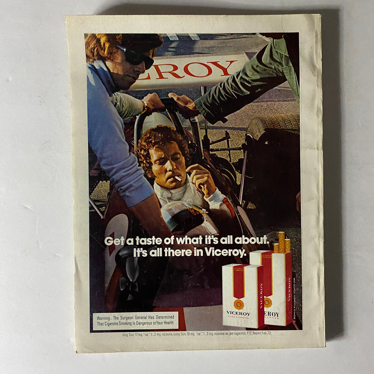 Esquire Magazine August 1973 showcasing a vintage Viceroy cigarette advertisement with a scene depicting a man in a racing car, highlighting its bold marketing message.