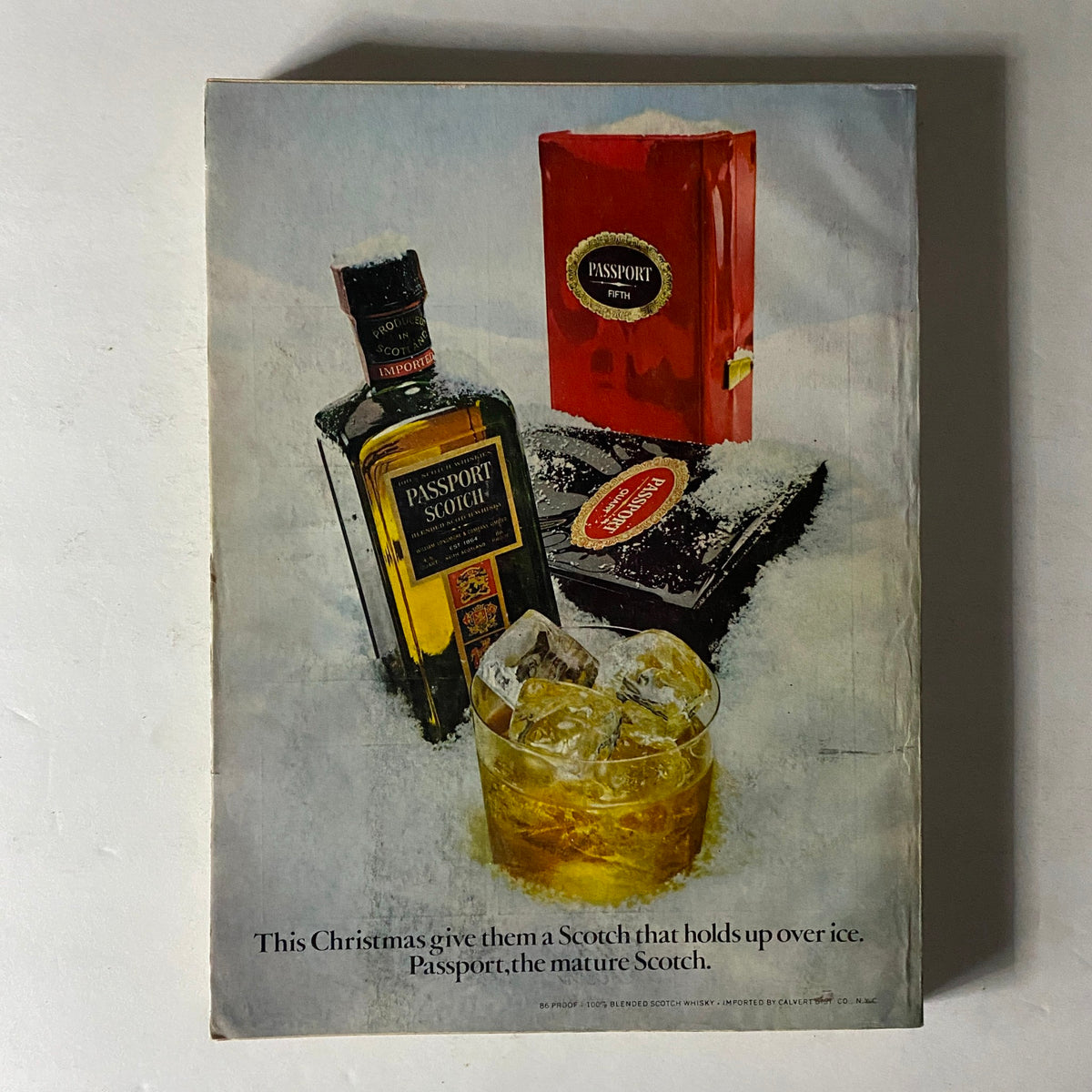 Esquire Magazine December 1972 advertisement for Passport Scotch, showcasing a bottle, glass of scotch with ice, and holiday-themed packaging.