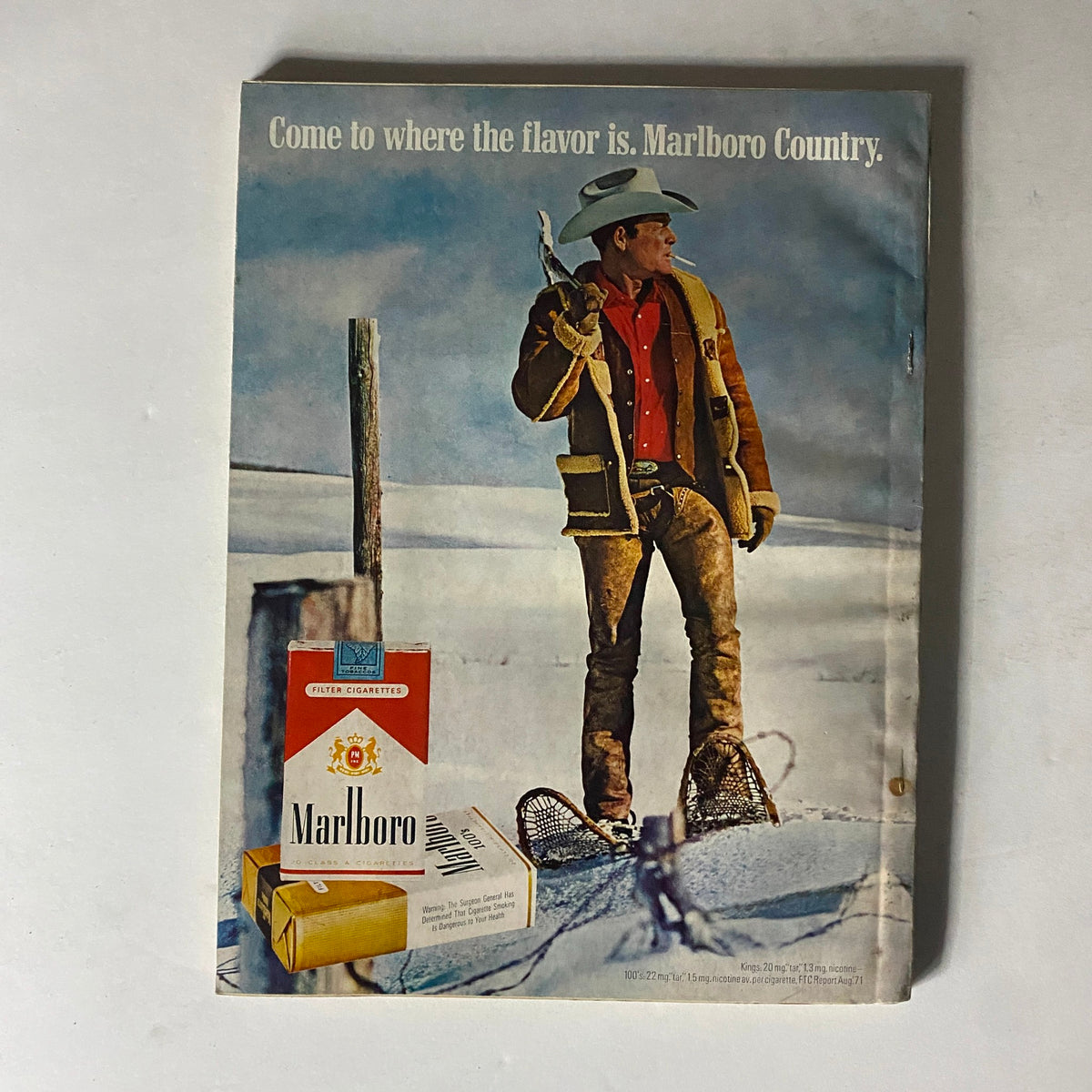 Vintage advertisement for Marlboro cigarettes featuring a cowboy in a snowy landscape, promoting the tagline 'Come to where the flavor is. Marlboro Country,' from the February 1972 Esquire Magazine with Teddy Kennedy on the cover.