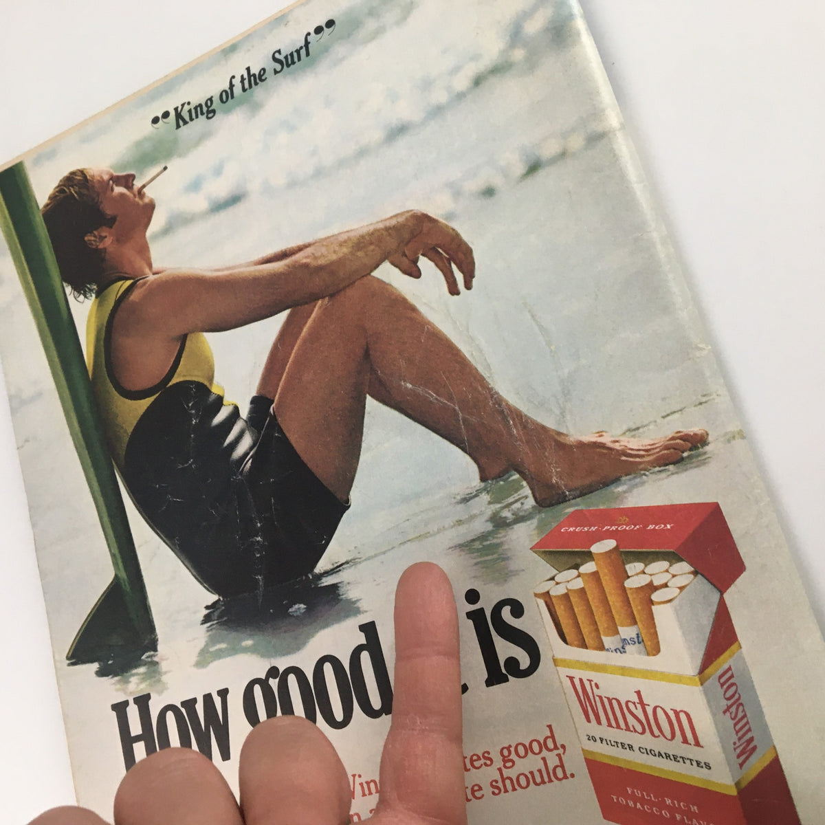 Vintage advertisement featuring a surfer with a cigarette, labeled 'King of the Surf,' promoting Winston cigarettes in the June 11, 1973 issue of US News & World Report magazine.