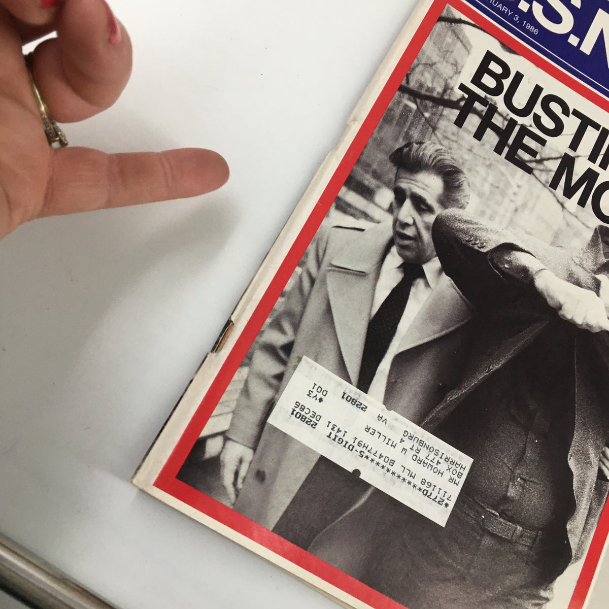 Close-up of the cover of US News & World Report Magazine February 3, 1986, focusing on the headline 'Busting the Mob' and a price tag alongside a hand pointing at the magazine.