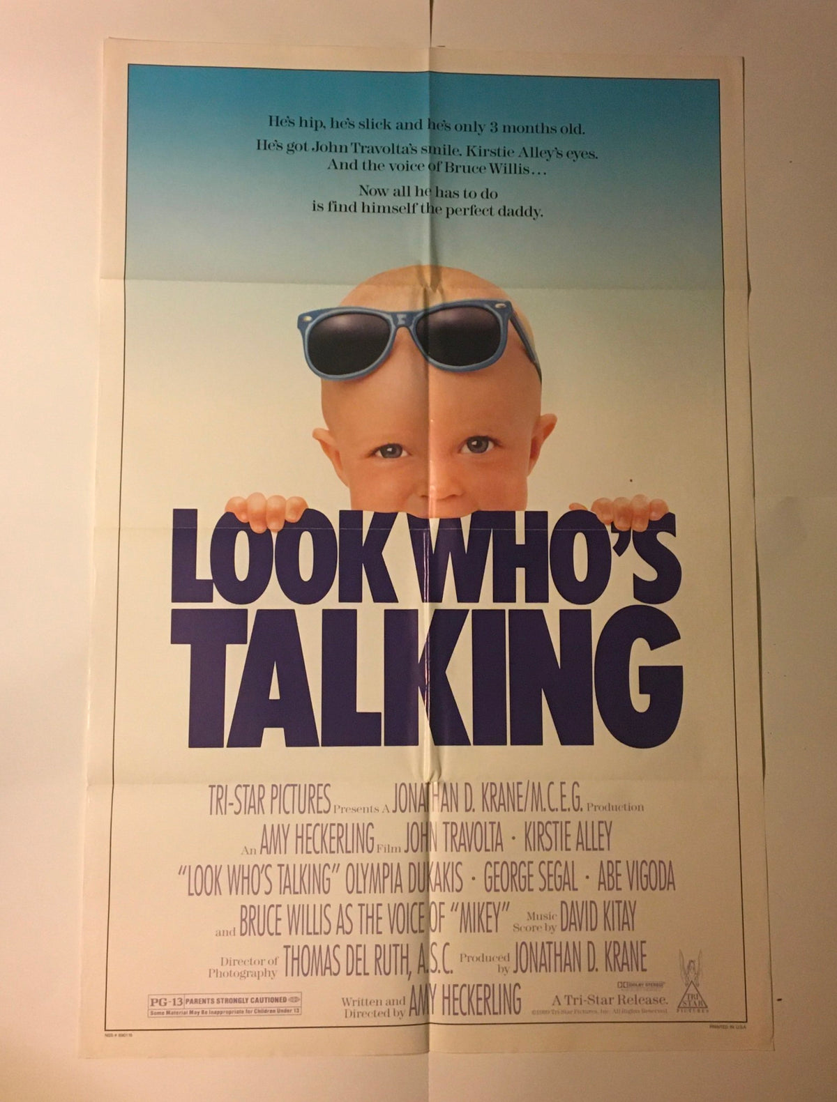 1989 Look Who's Talking 41" x 27" Original Movie Poster highlighting John Travolta, featuring a playful infant wearing sunglasses and emphasizing the movie's humorous taglines.