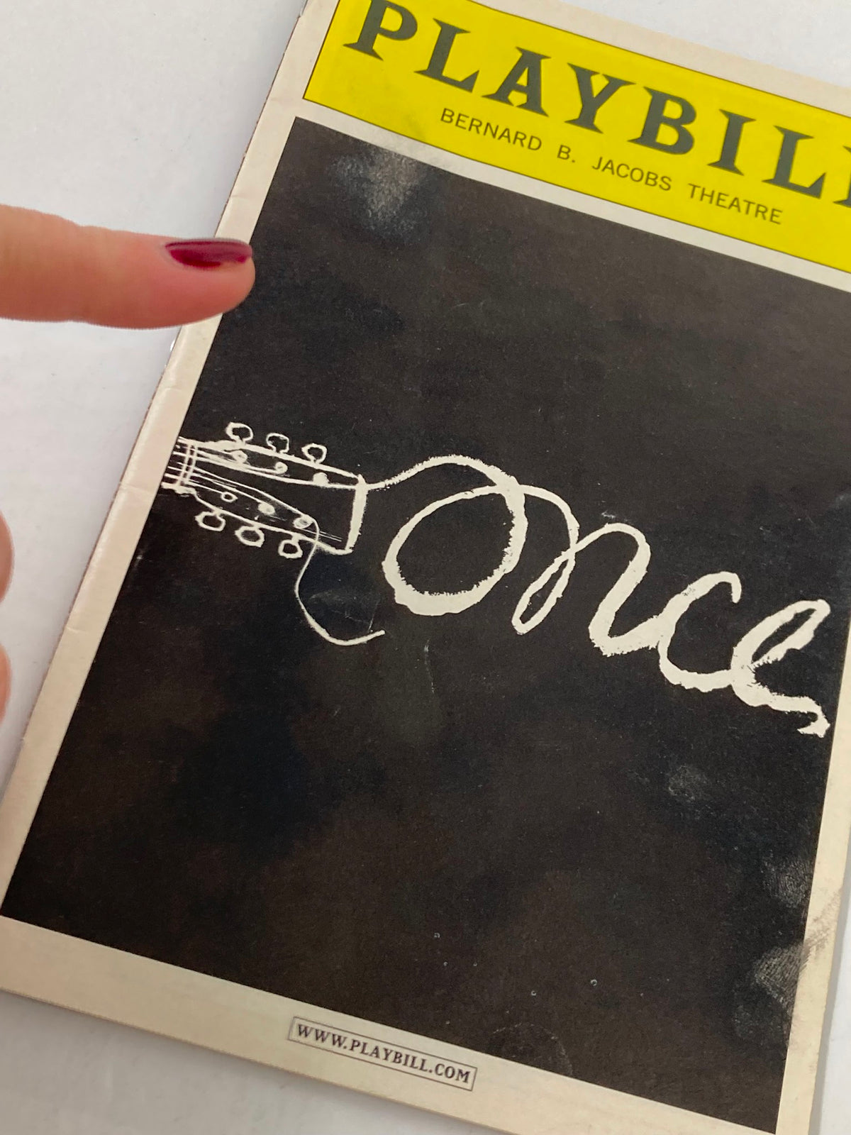 Close-up of the 2012 Playbill for Once at Bernard B. Jacobs Theatre, highlighting the cover art with a guitar and the name 'Once'.