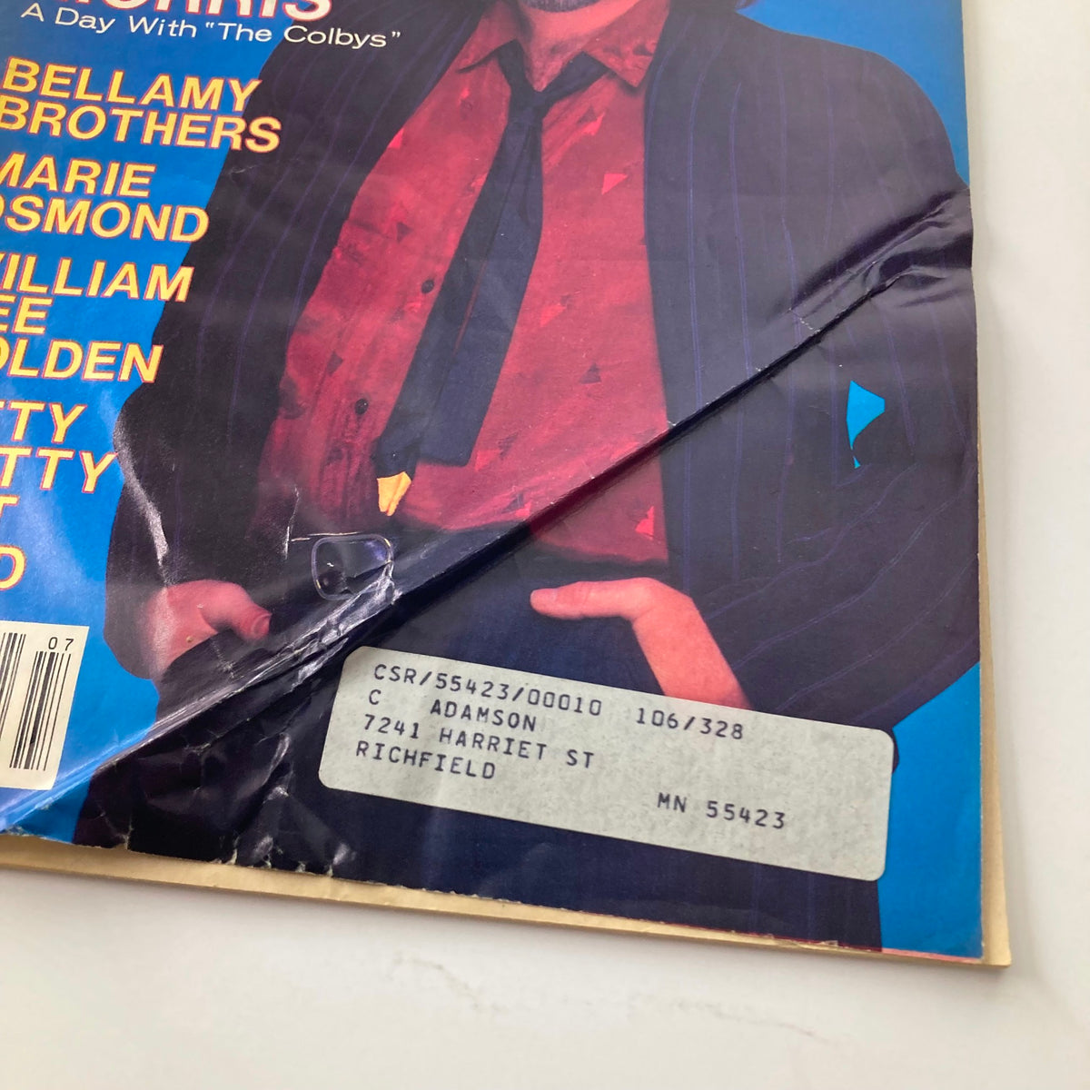 Close-up of the VTG Country Song Roundup Magazine July 1986 cover highlighting Garry Morris and featuring a damaged corner, showing details such as the title 'A Day with The Colbys' and magazine pricing.