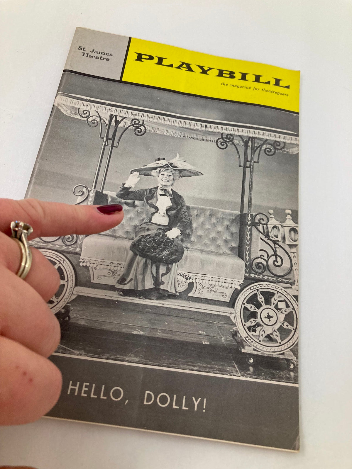 1965 Playbill from St. James Theatre with Carol Channing in Hello, Dolly! highlighted by a hand pointing to the cover.