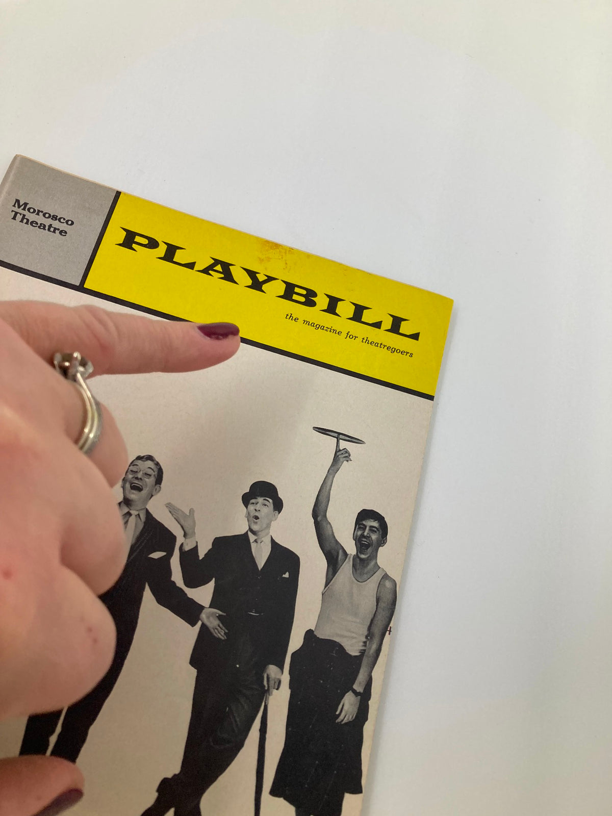 Close-up view of the 1964 Playbill from The Morosco Theatre highlighting the title The Private Ear and The Public Eye, with a finger pointing to the Playbill logo.