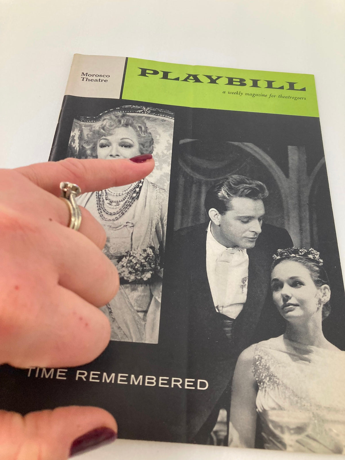 1958 Playbill at Morosco Theatre featuring Helen Hayes and Richard Burton in 'Time Remembered', showcasing a finger pointing at the cover.