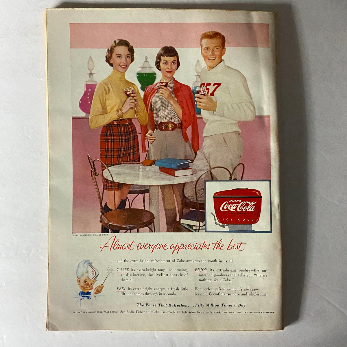 Back cover of a vintage magazine promoting Coca-Cola, showcasing a group of young adults enjoying the beverage in a retro setup.