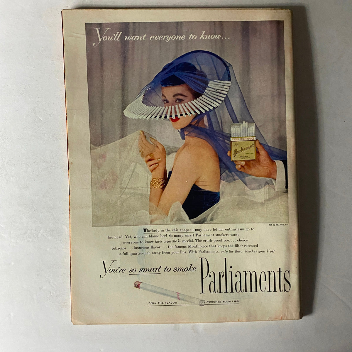 Back cover advertisement of Time Magazine from October 24, 1955, for Parliament cigarettes, featuring an elegant woman wearing a large hat and holding a pack of cigarettes.