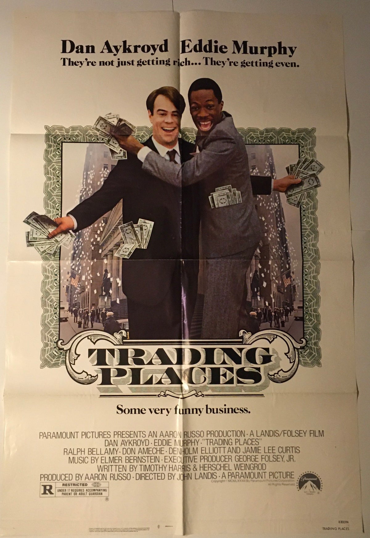1983 Trading Places 41" x 27" Original Movie Poster with Eddie Murphy and Dan Aykroyd, displaying a comedic moment surrounded by cash against an urban skyline.
