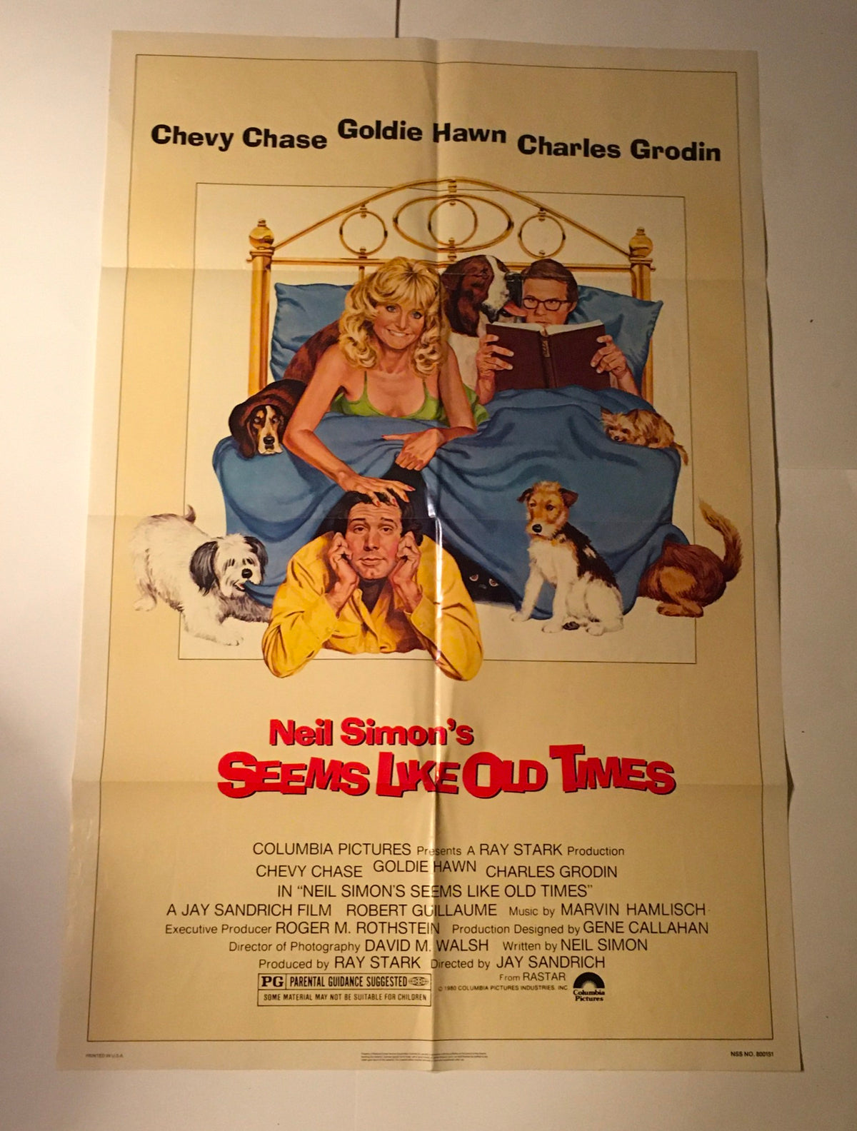 1980 Seems Like Old Times 41" x 27" Original Movie Poster featuring Chevy Chase, Goldie Hawn, and Charles Grodin, with a playful scene on a bed surrounded by various dogs, highlighting the charm of classic cinema.