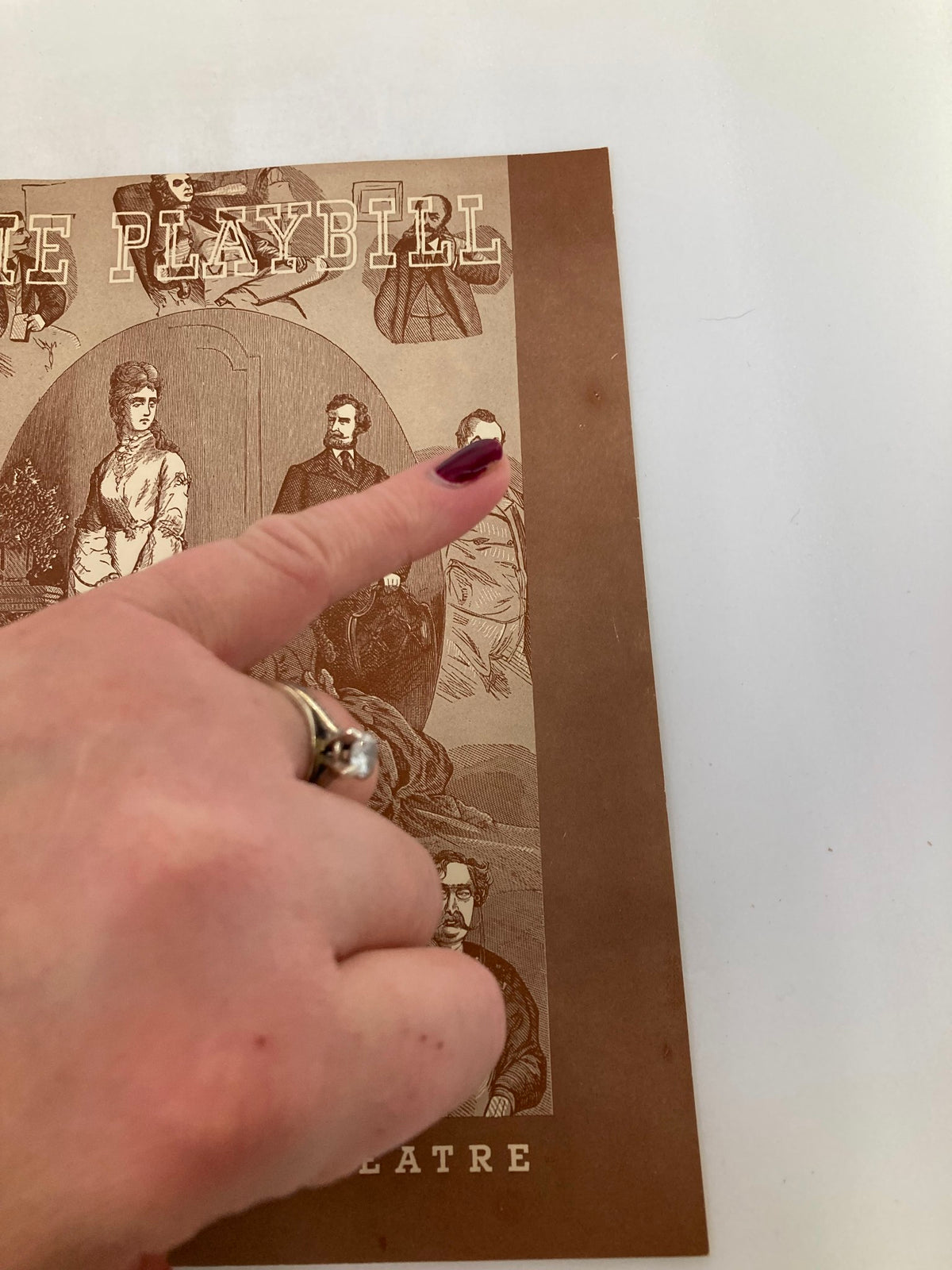 1943 Playbill from John Golden Theatre with a hand pointing at character illustrations from Angel Street, highlighting its vintage details.