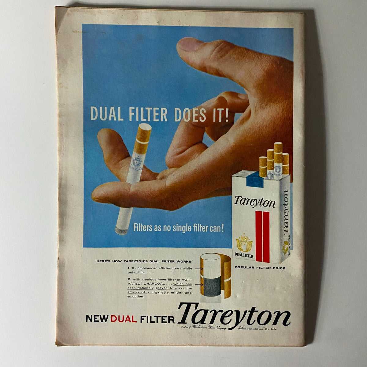 Vintage advertisement for Tareyton cigarettes showcasing the dual filter feature, with a hand holding a cigarette pack.