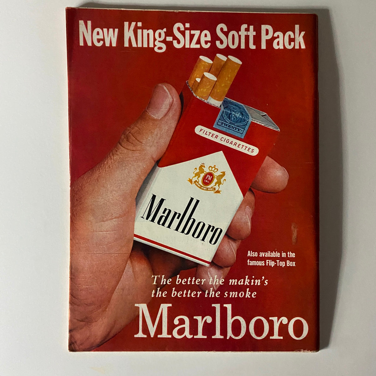 Vintage Marlboro advertisement featuring a hand holding a new king-size soft pack cigarette box, highlighting classic branding.