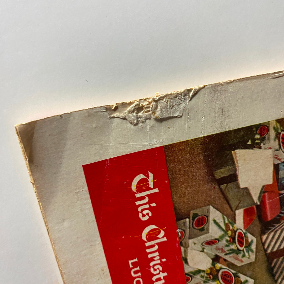 Detail of the top corner from the Time Magazine December 12, 1955, Vol 66 No. 24 cover showing a partially torn area with gifting promotion text and a visual of Christmas gifts.